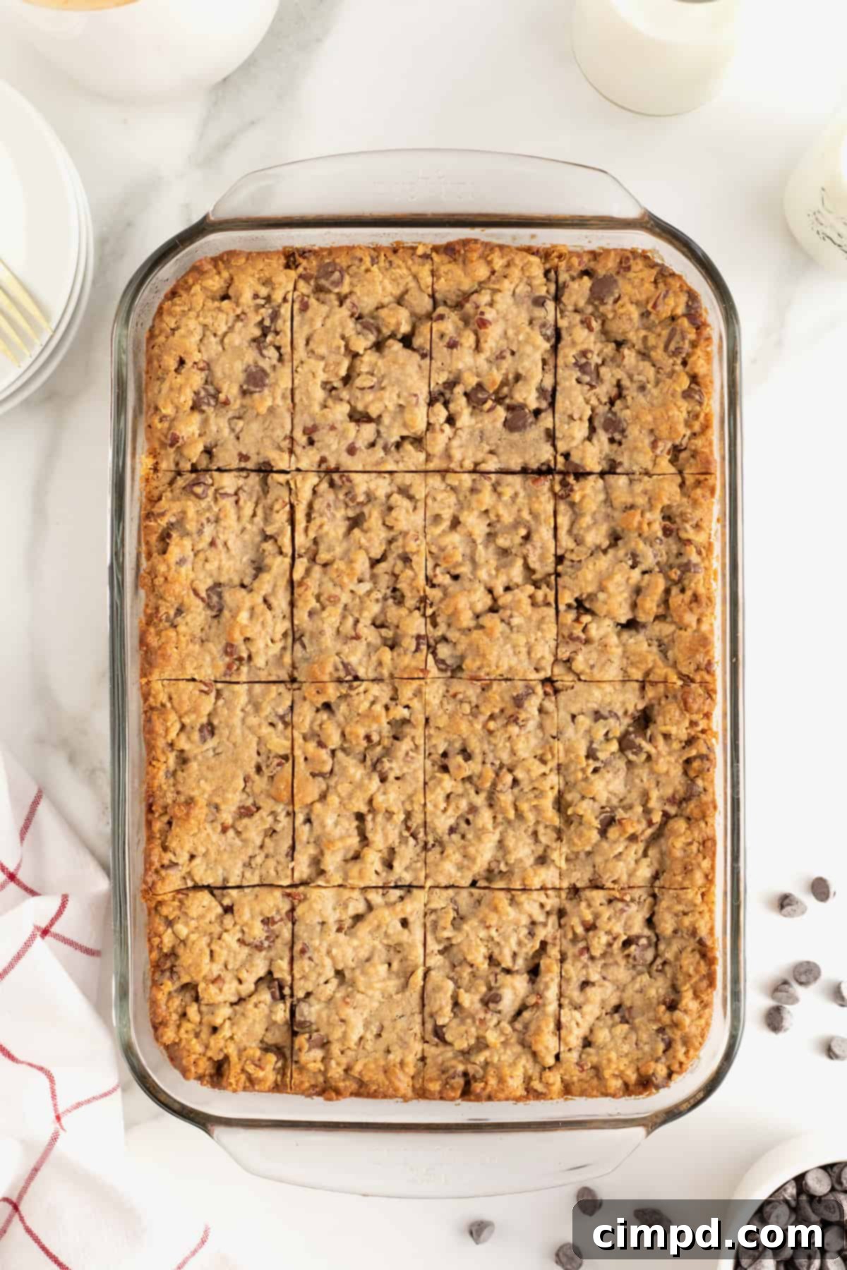 Homemade Chocolate Chip Granola Bars 10 A glass baking dish of granola bars cut into pieces. Chocolate chips are scattered at the bottom right corner.