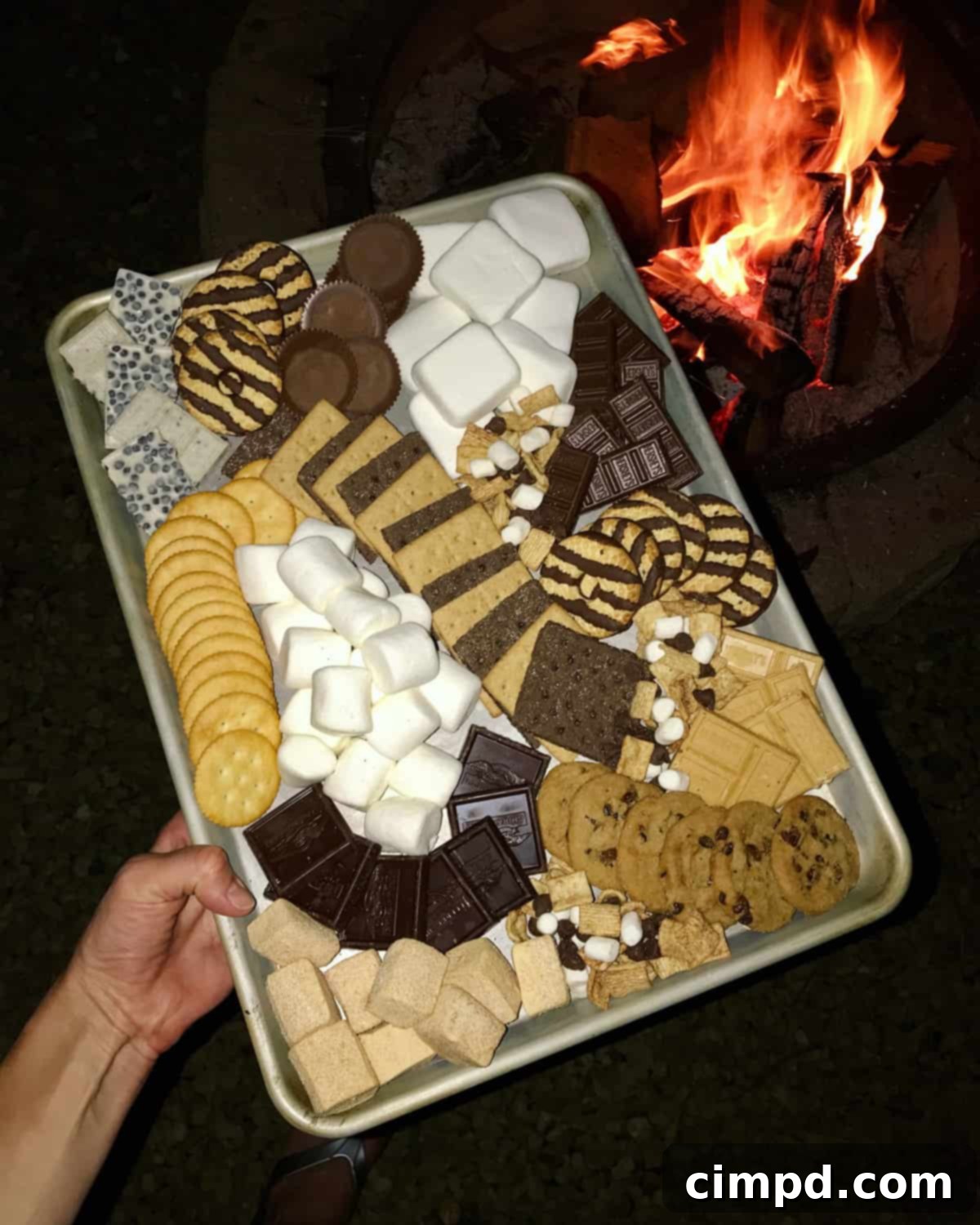 A close-up shot of a perfectly toasted marshmallow on a roasting stick, ready to be placed on a S'mores Board.