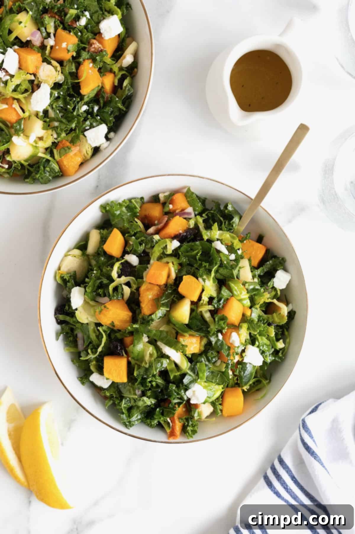 Vibrant Kale and Brussels Sprouts Salad 11 A gold-rimmed white salad bowl filled with kale and Brussels sprouts salad.