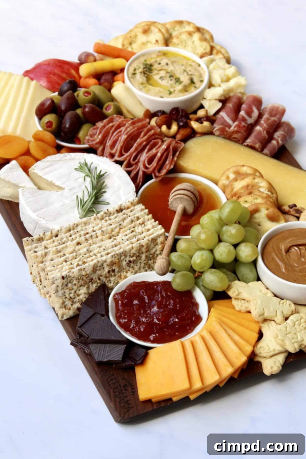 The Ultimate Holiday Grazing Board with serving bowls strategically placed to define the layout and prepare for the arrangement of other ingredients.