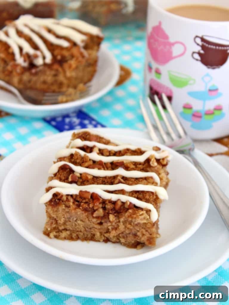 A delectable Cream Cheese Coffee Cake, showcasing its moist texture, pecan crumb topping, and a sweet cream cheese drizzle, sliced and ready to serve.
