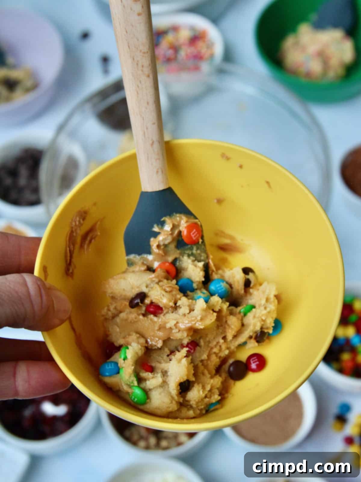 Craft Your Own Cookie Magic 5 A child's hands mixing chocolate chips into cookie dough in a small bowl