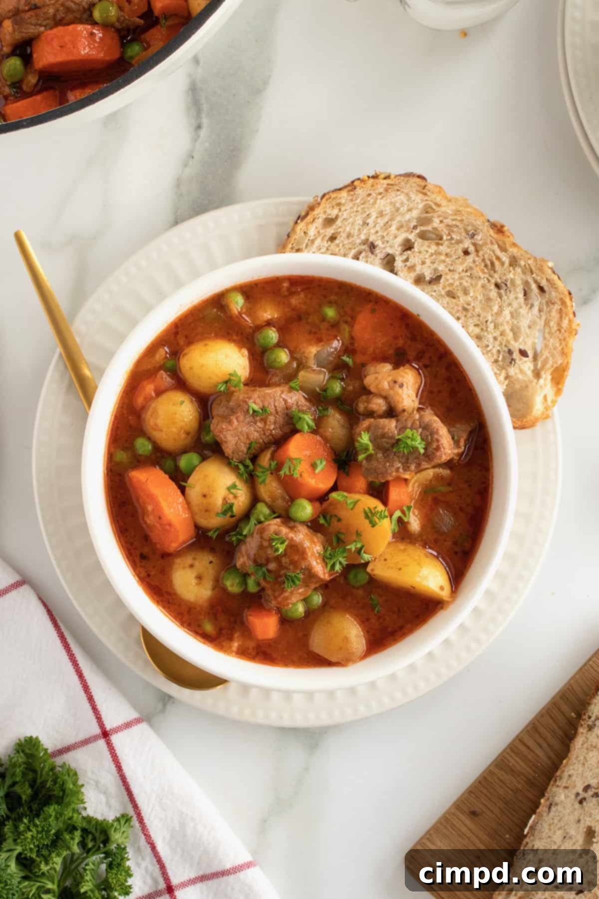 Close-up of beef stew with carrots, potatoes, and savory sauce.
