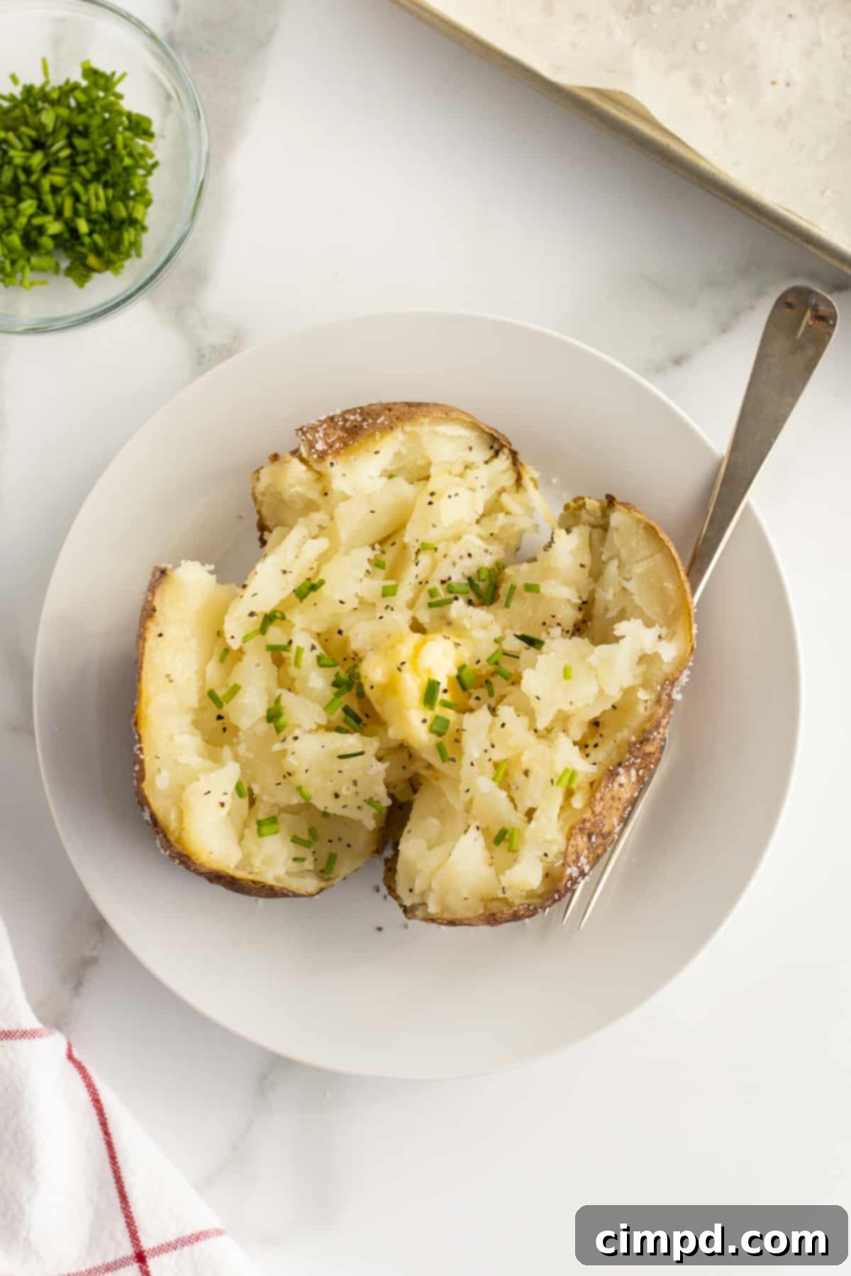 Close-up of a baked potato being prepared for baking by The BakerMama.