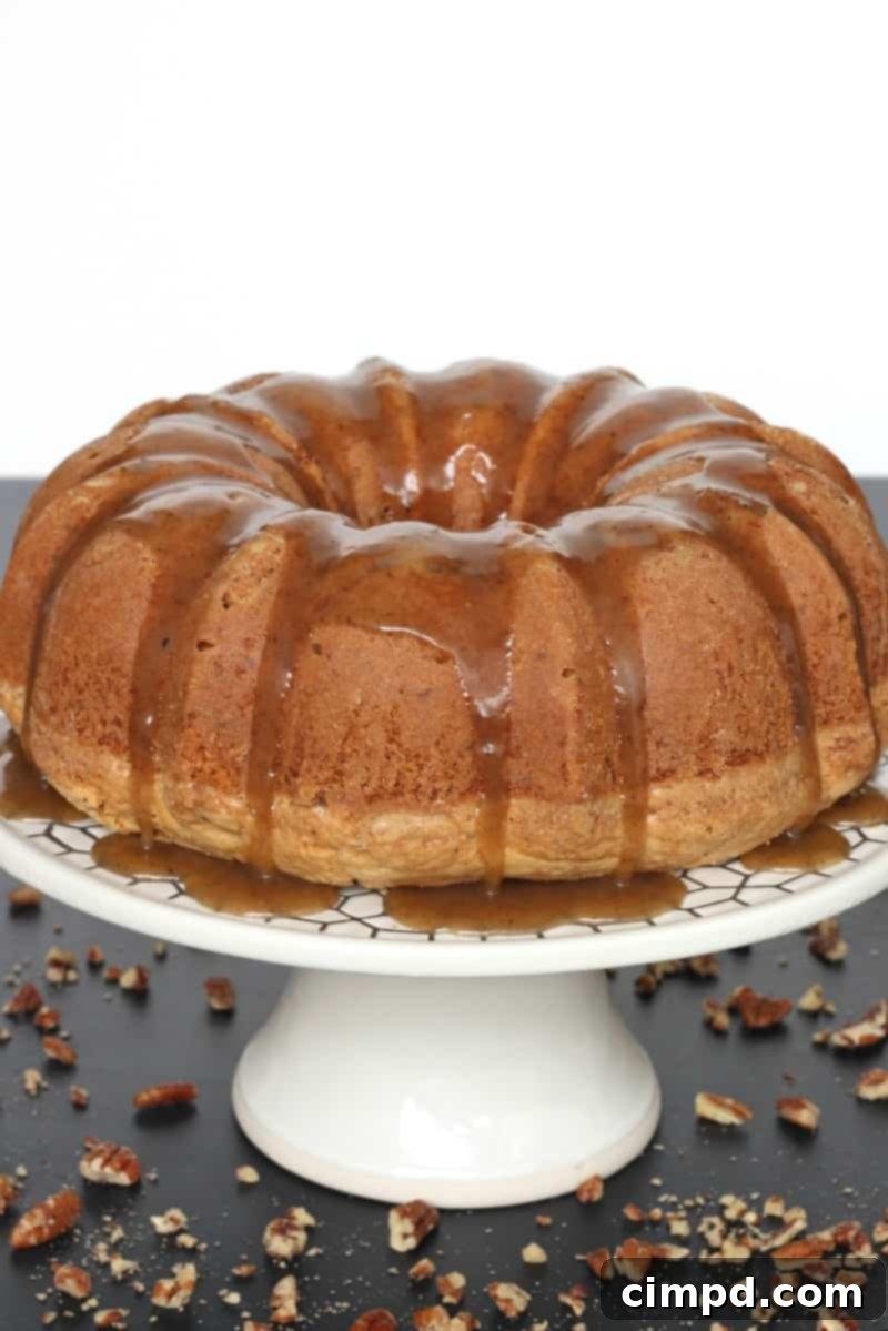 A stunning Brown Butter Pecan Pound Cake drizzled with Brown Butter Caramel Sauce, emphasizing its golden-brown crust and rich texture.