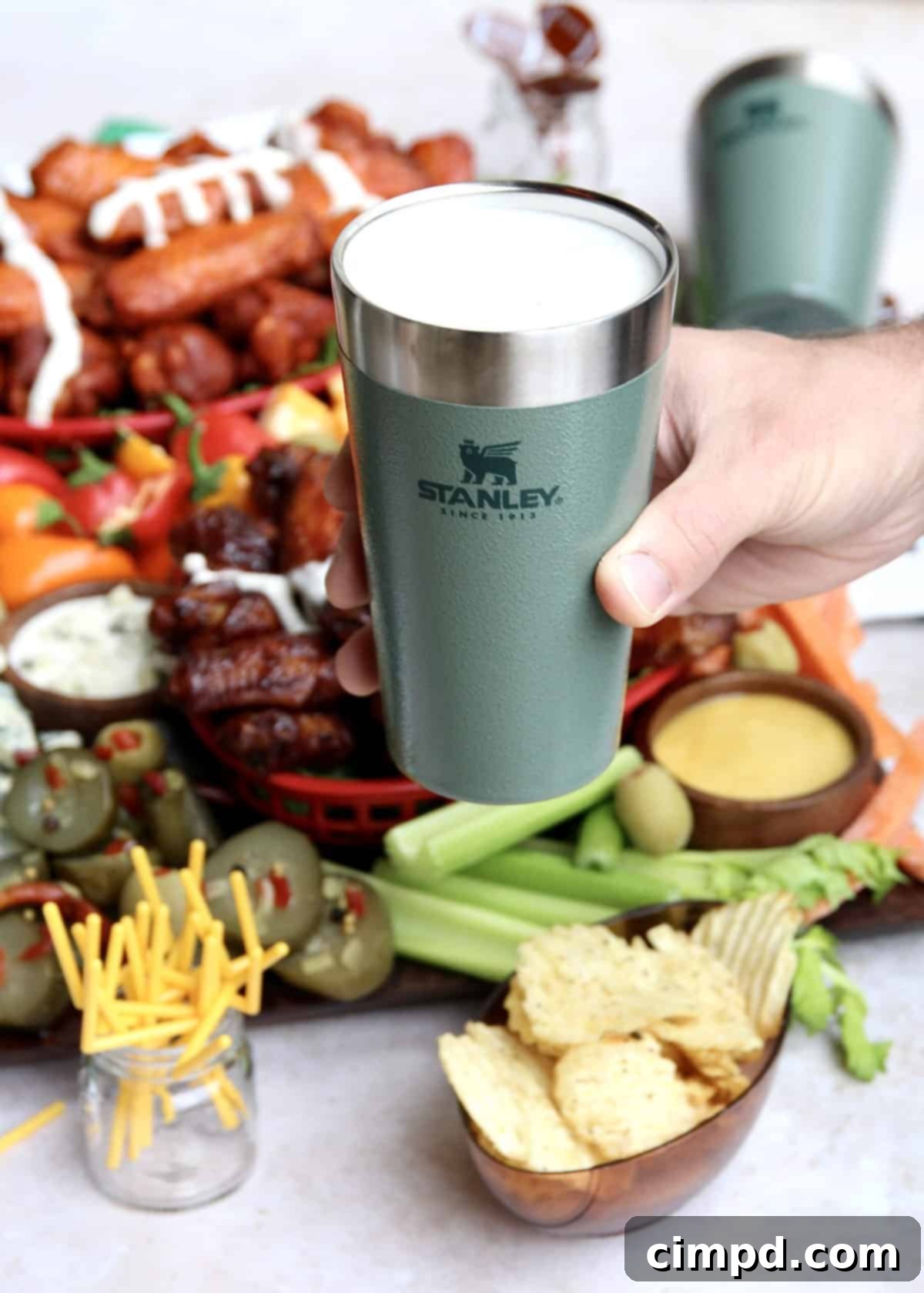 Ultimate Wing Spread 5 A person assembling the Chicken Wings Snack Board with various ingredients.