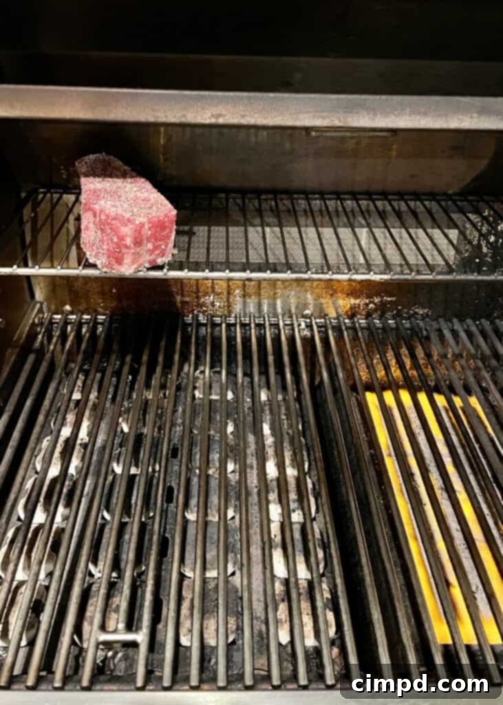 How to Reverse Sear a Steak: steak cooking on the indirect heat side of the grill