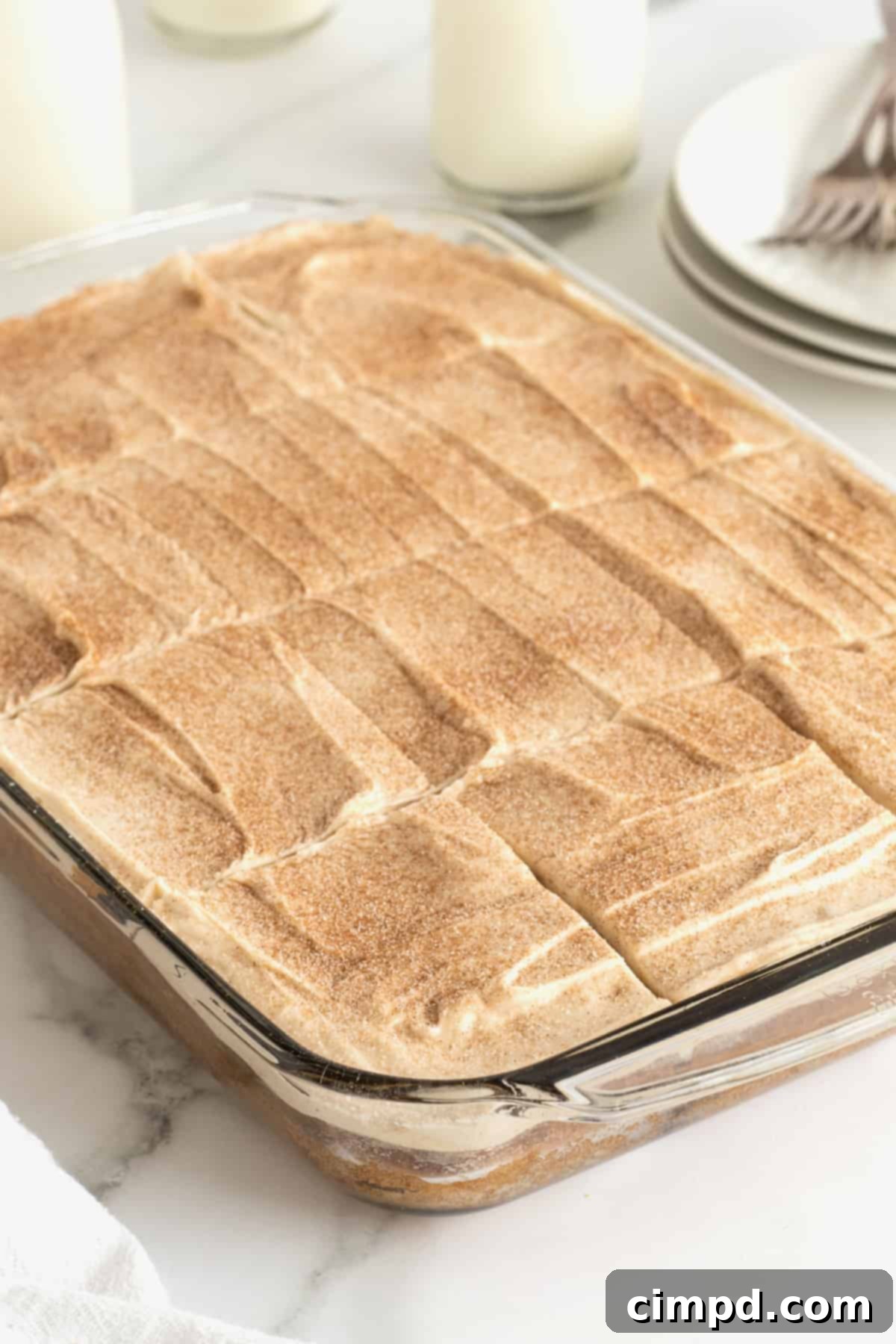 A beautifully frosted zucchini cake, sprinkled with cinnamon sugar, ready for serving or storage.