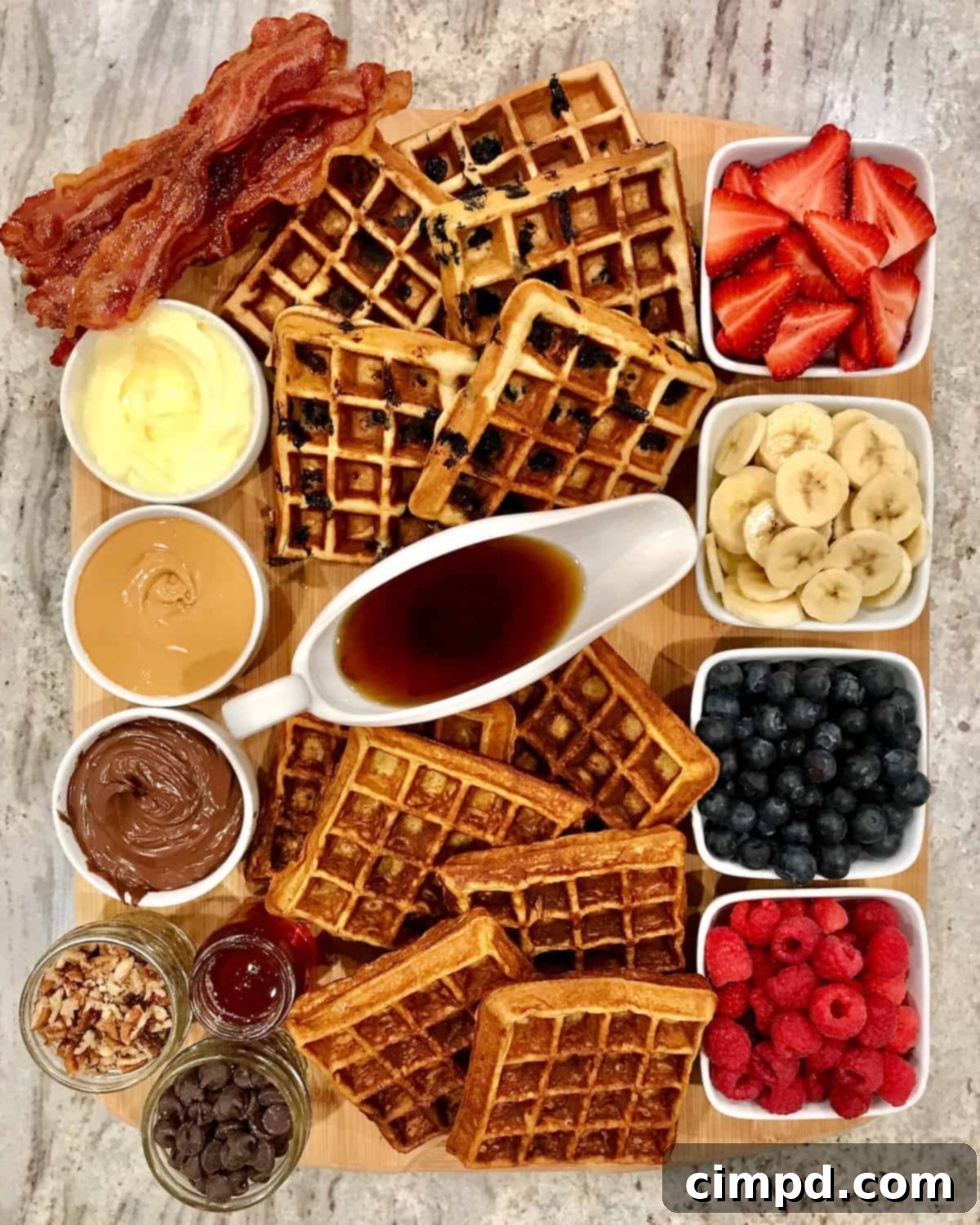 A vibrant Build-Your-Own Waffle Board by The BakerMama, featuring a variety of waffles and toppings, including Nutella.