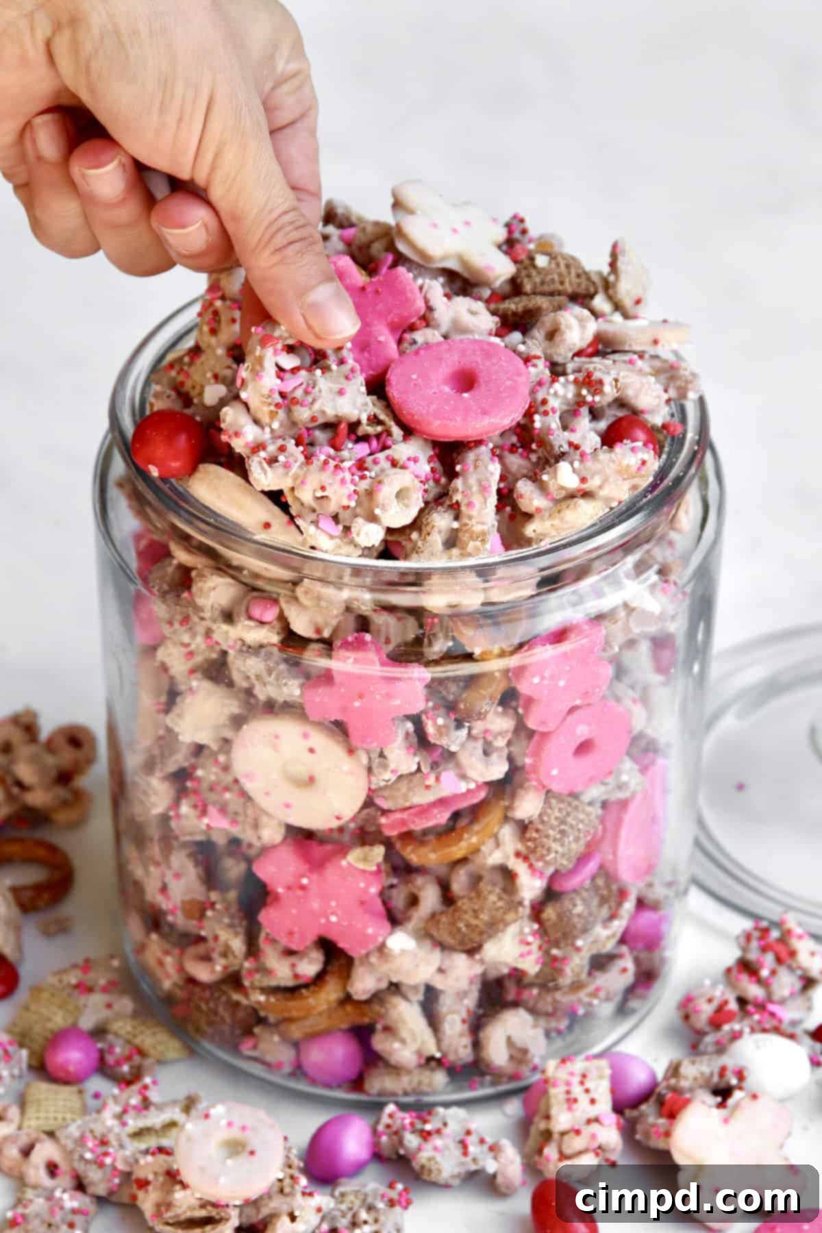A glass jar filled with XOXO Valentine's Day Snack Mix, ready for serving or gifting.