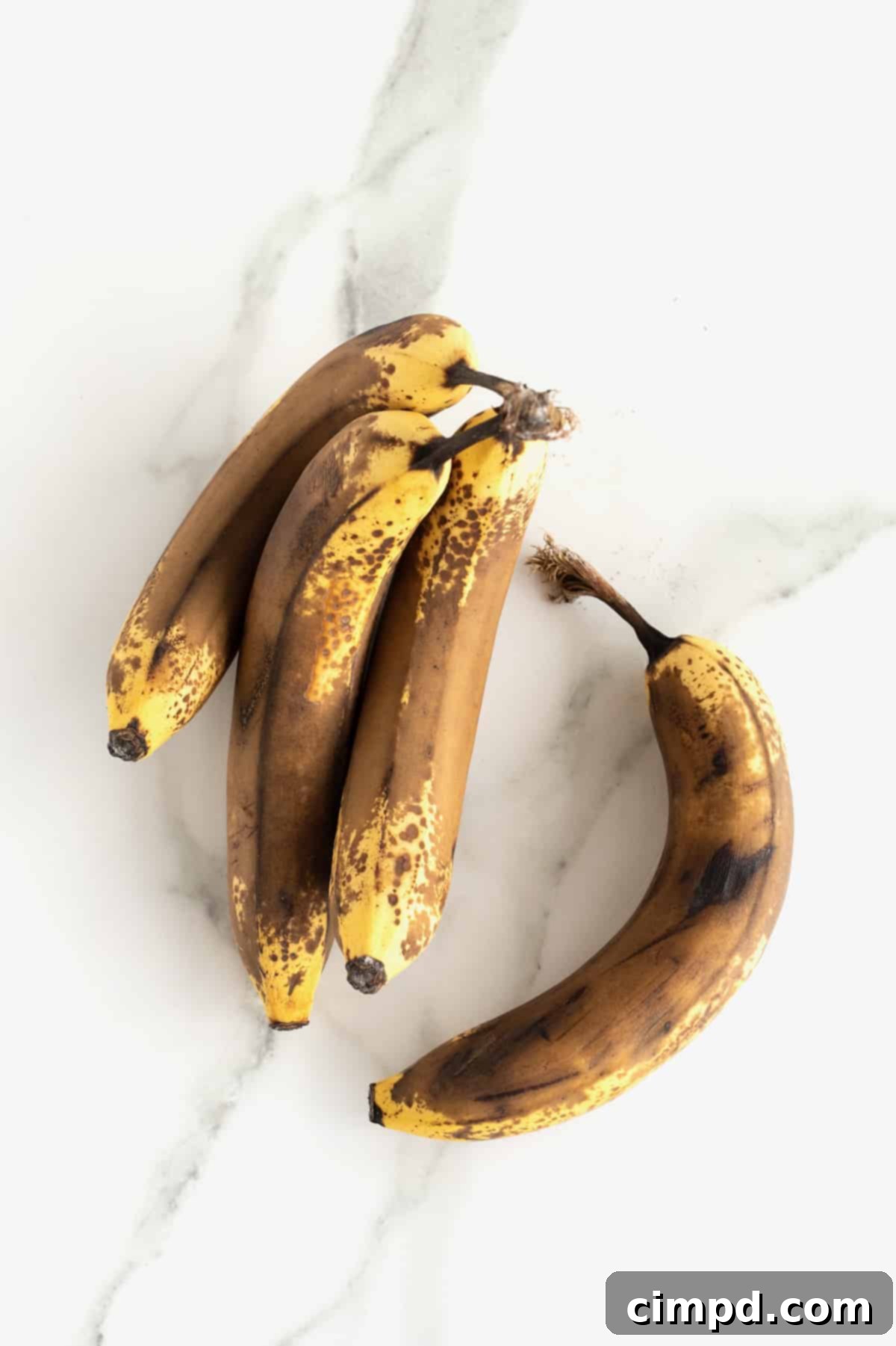 Brown bananas on a white marble counter.