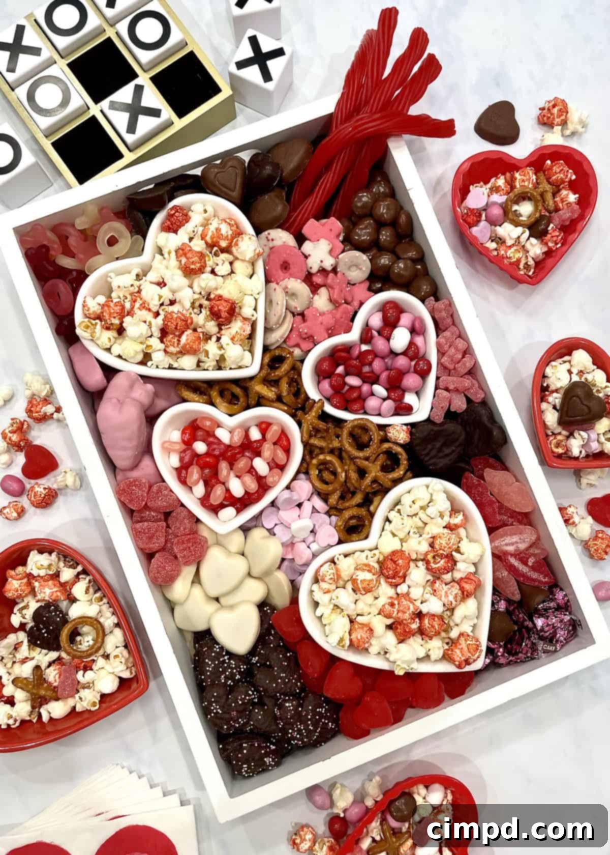 A vibrant Valentine's Day Movie Night Snack Board overflowing with a variety of themed treats and heart-shaped dishes, perfect for a cozy celebration.