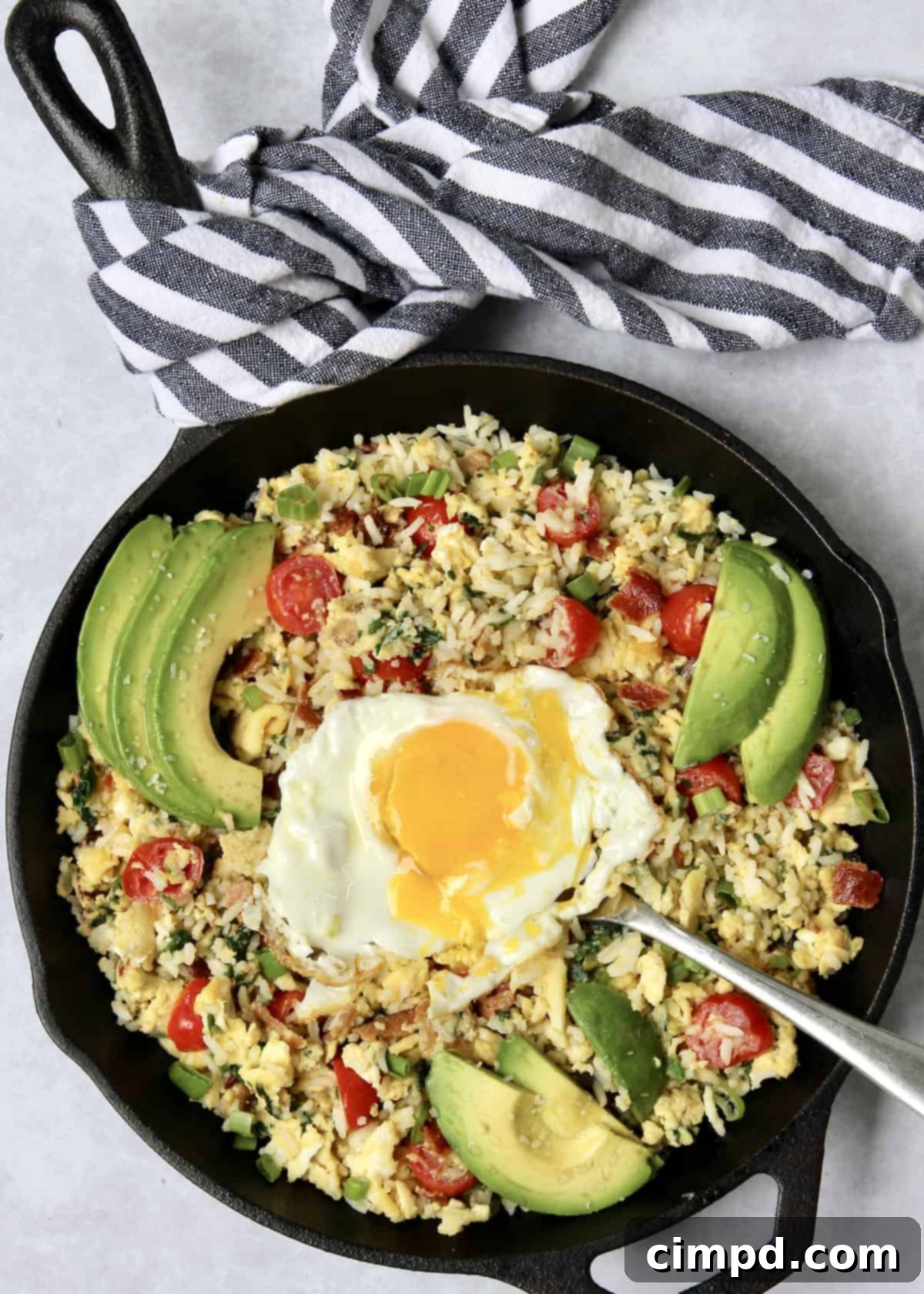 Close-up of a skillet filled with a vibrant Breakfast Rice Scramble.