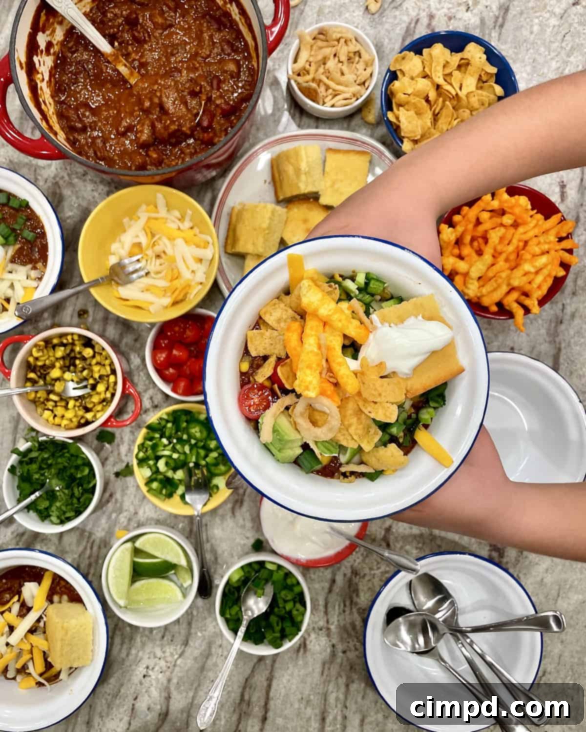 An inviting close-up of a filled chili bowl, showcasing a rich chili base with melty cheese, a dollop of sour cream, and fresh green onions, ready to be enjoyed.