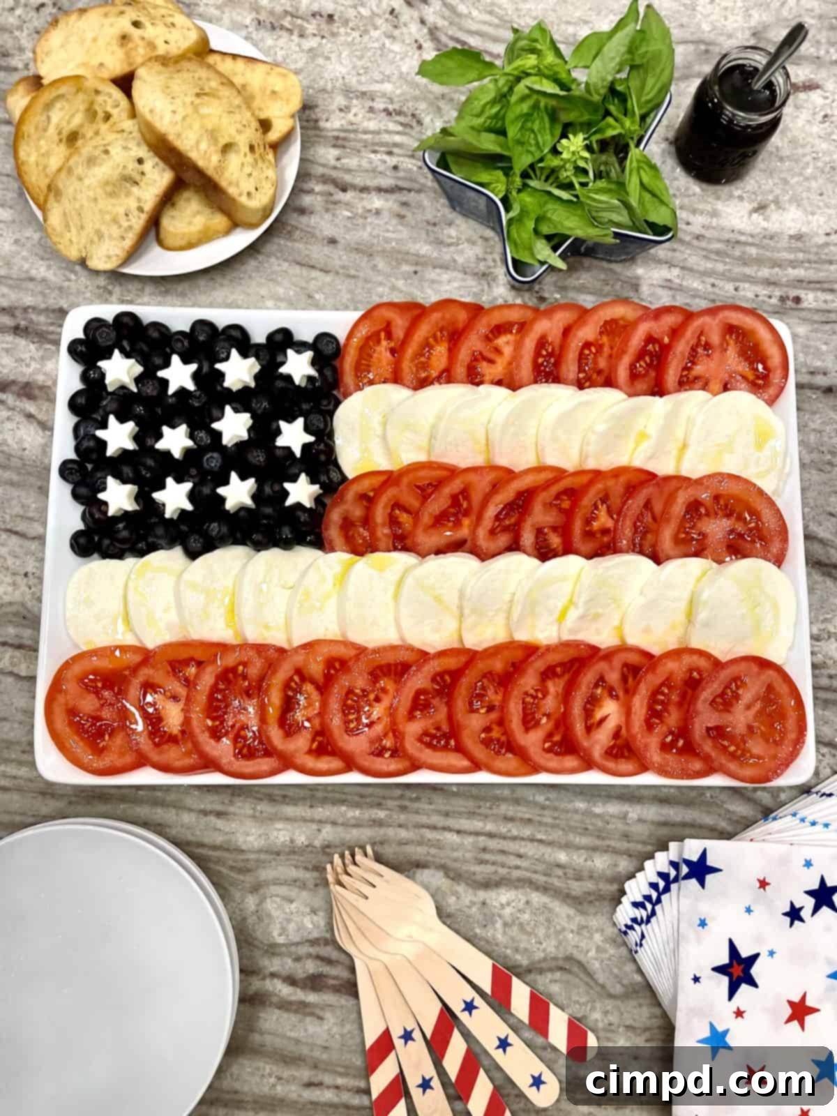 Vibrant American Flag Caprese Salad with toasted baguette and blueberry balsamic drizzle, perfect for patriotic celebrations.