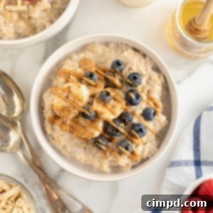 Perfect Steel Cut Oats Every Time 14 A bowl of steel cut oatmeal topped with banana slices and fresh blueberries and drizzled with peanut butter.