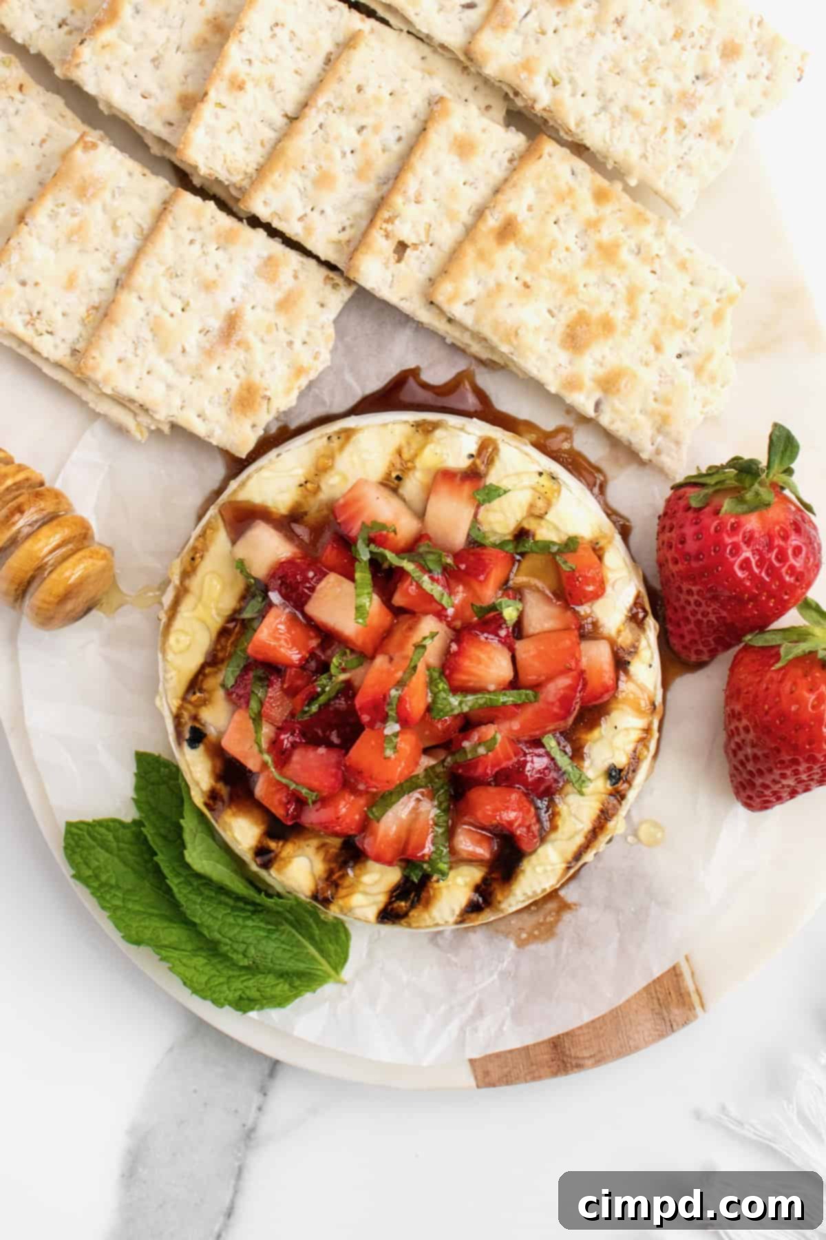 Delicious Grilled Brie with Strawberries, honey, and mint ready to be enjoyed