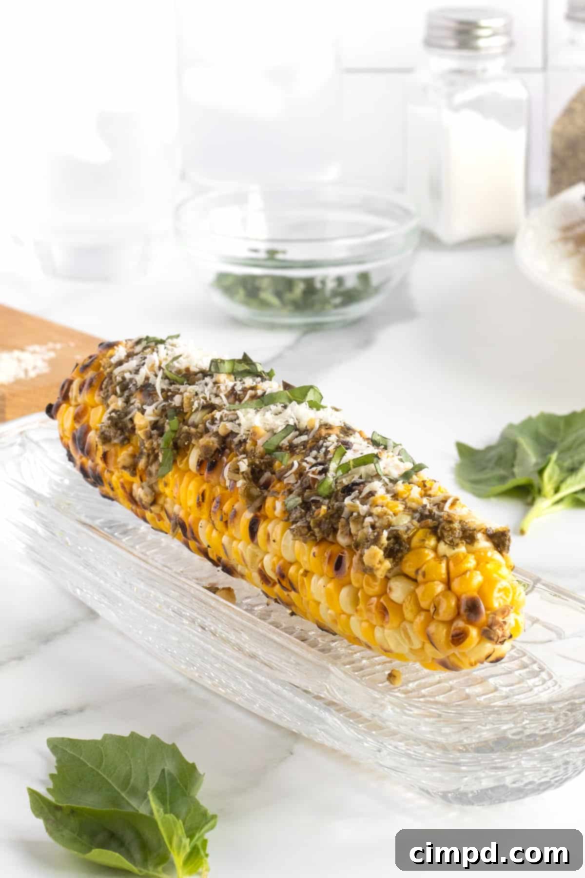 Grilled Corn with Pesto and Parmesan 3 Close-up of Pesto Parmesan Grilled Corn, showcasing the basil and cheese by The BakerMama