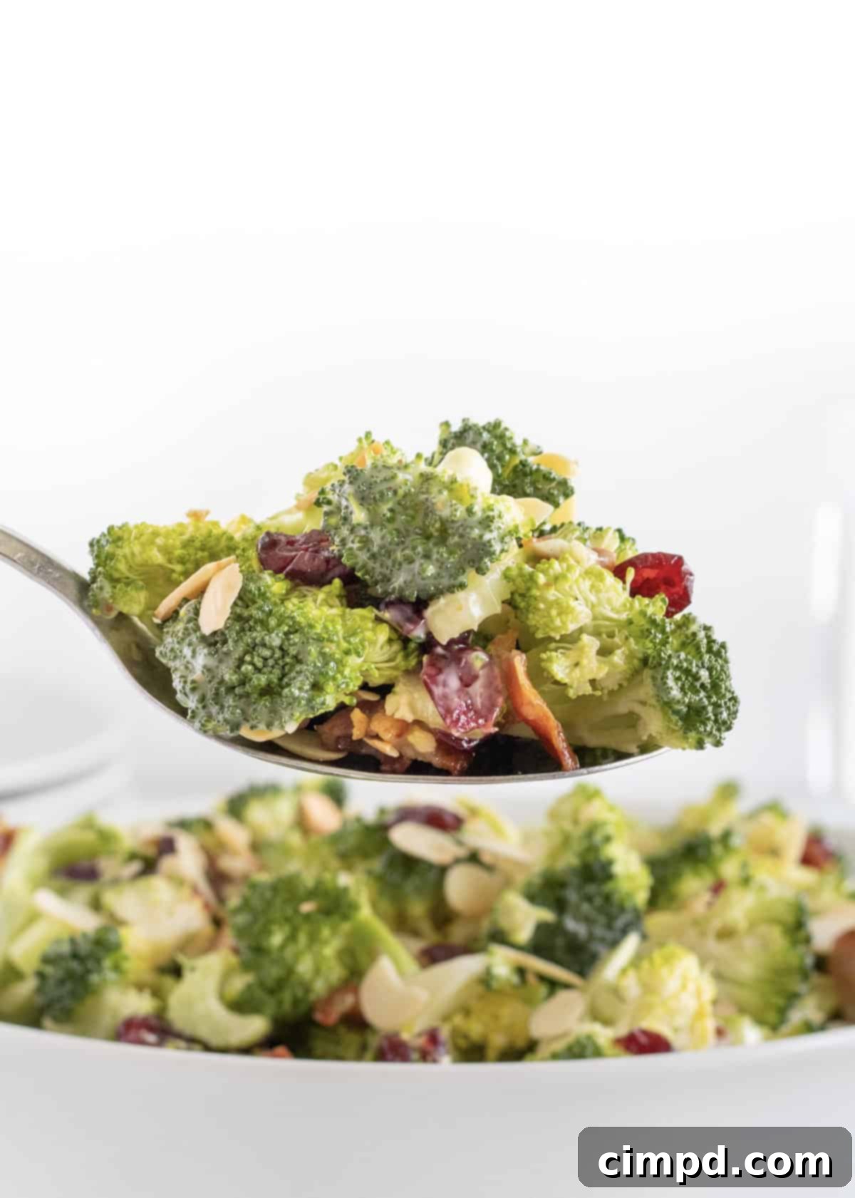 Close-up of Creamy Broccoli Salad in a white bowl, showcasing its vibrant ingredients.