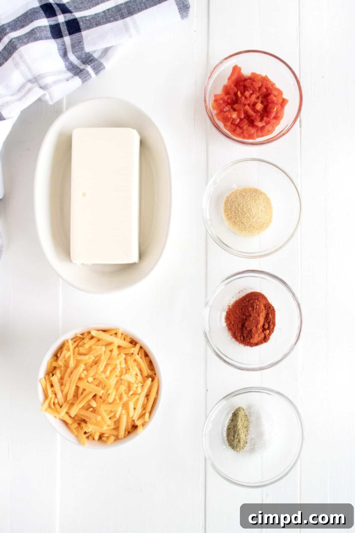 A flat lay photograph showcasing all the fresh ingredients neatly arranged for making Pimento Cheese Dip: cream cheese, shredded cheddar, pimentos, and spices.