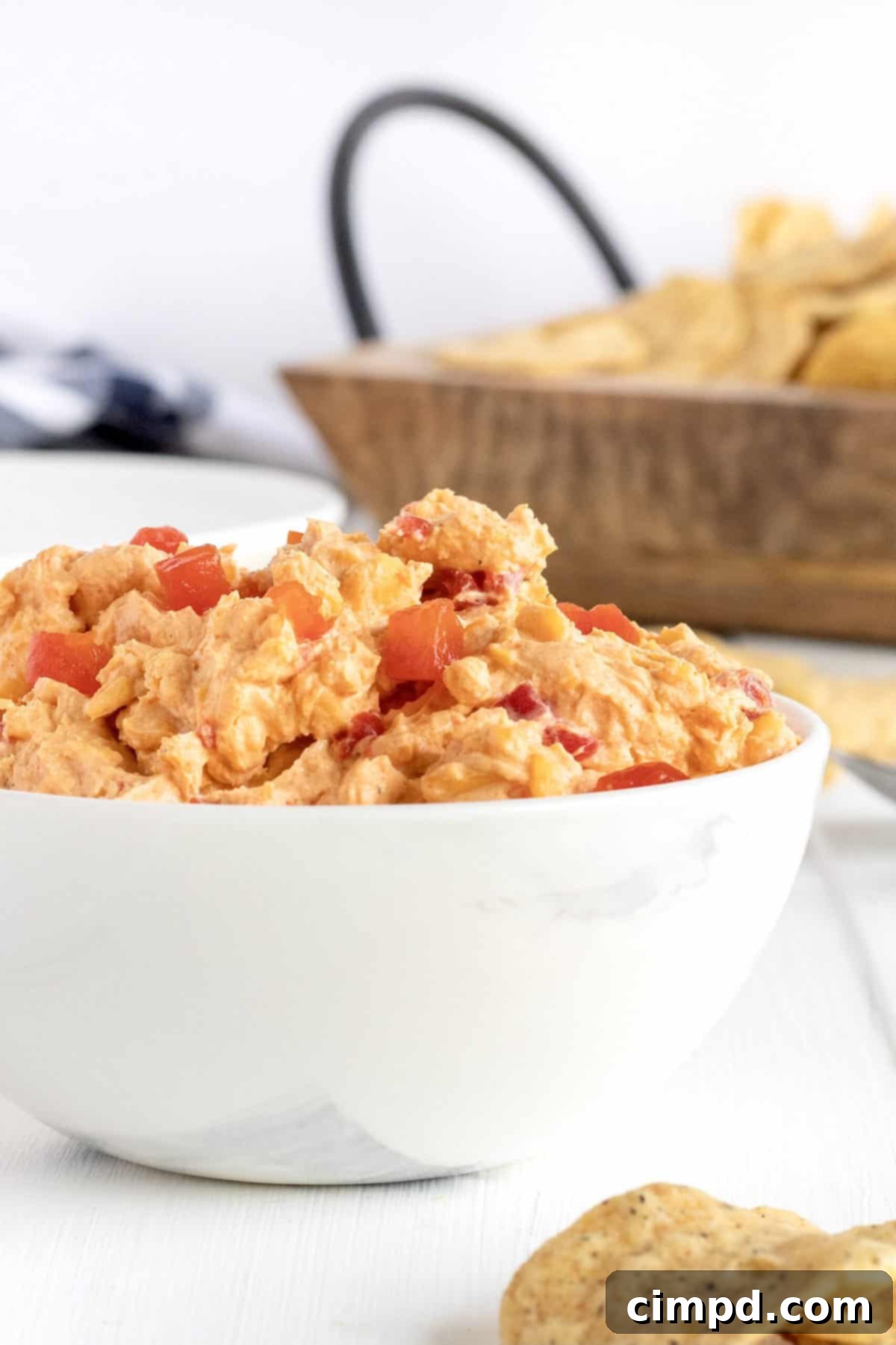 A close-up of a bowl of Pimento Cheese Dip, perfectly chilled and ready to be served, showcasing its vibrant color and creamy texture.
