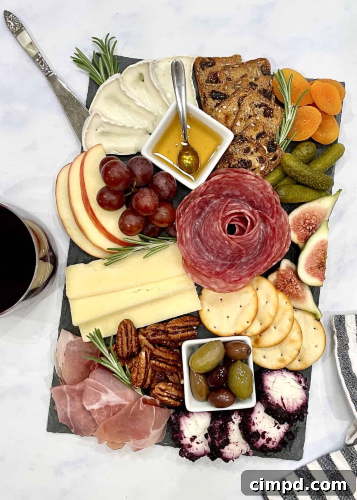 A beautifully assembled mini charcuterie board from Trader Joe's, featuring a harmonious arrangement of cheeses, cured meats, fresh and dried fruits, nuts, olives, and crackers, elegantly presented on a small wooden serving board.