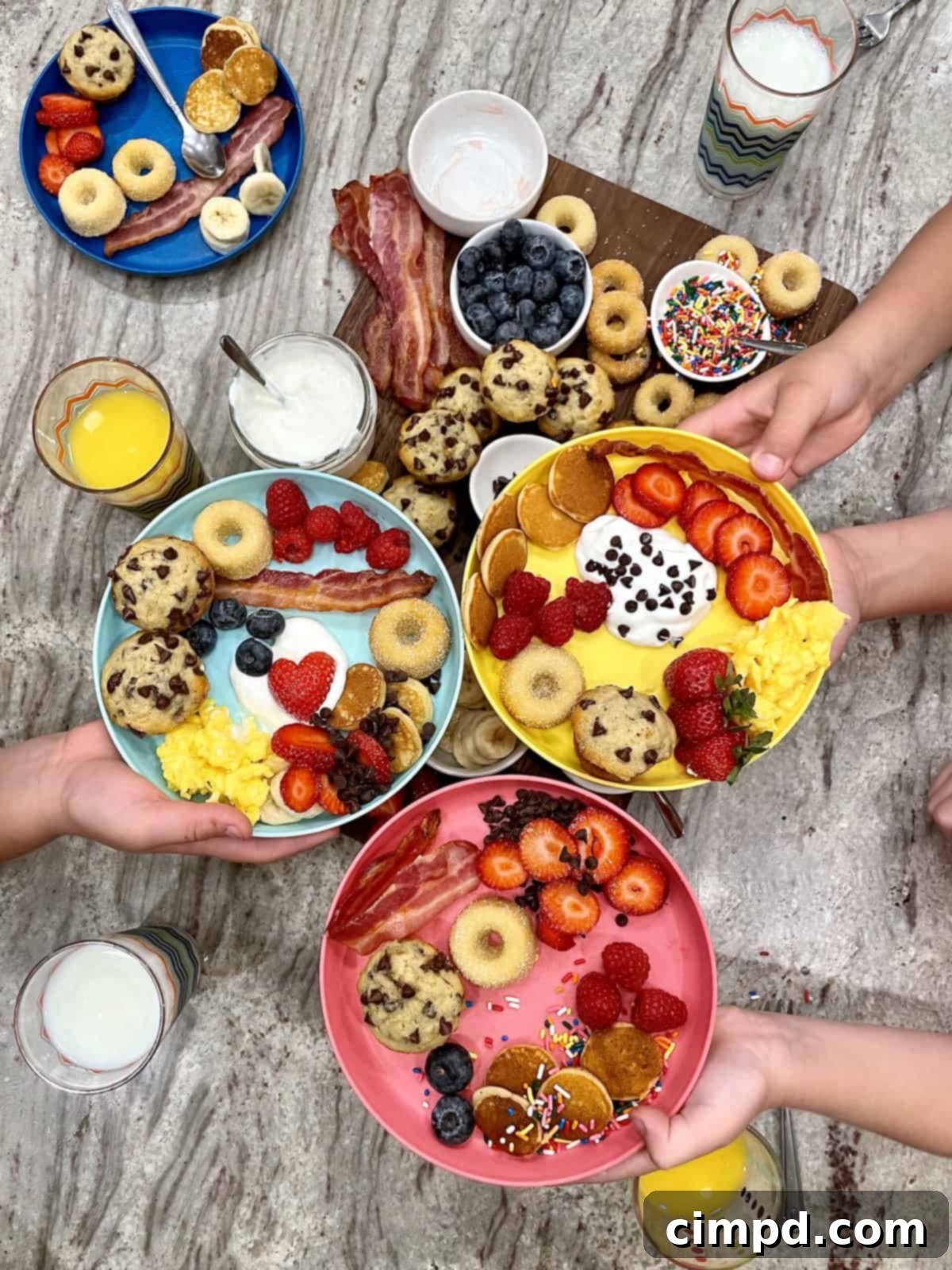 Overhead view of a beautiful breakfast board with mini muffins, fruit, and donuts.