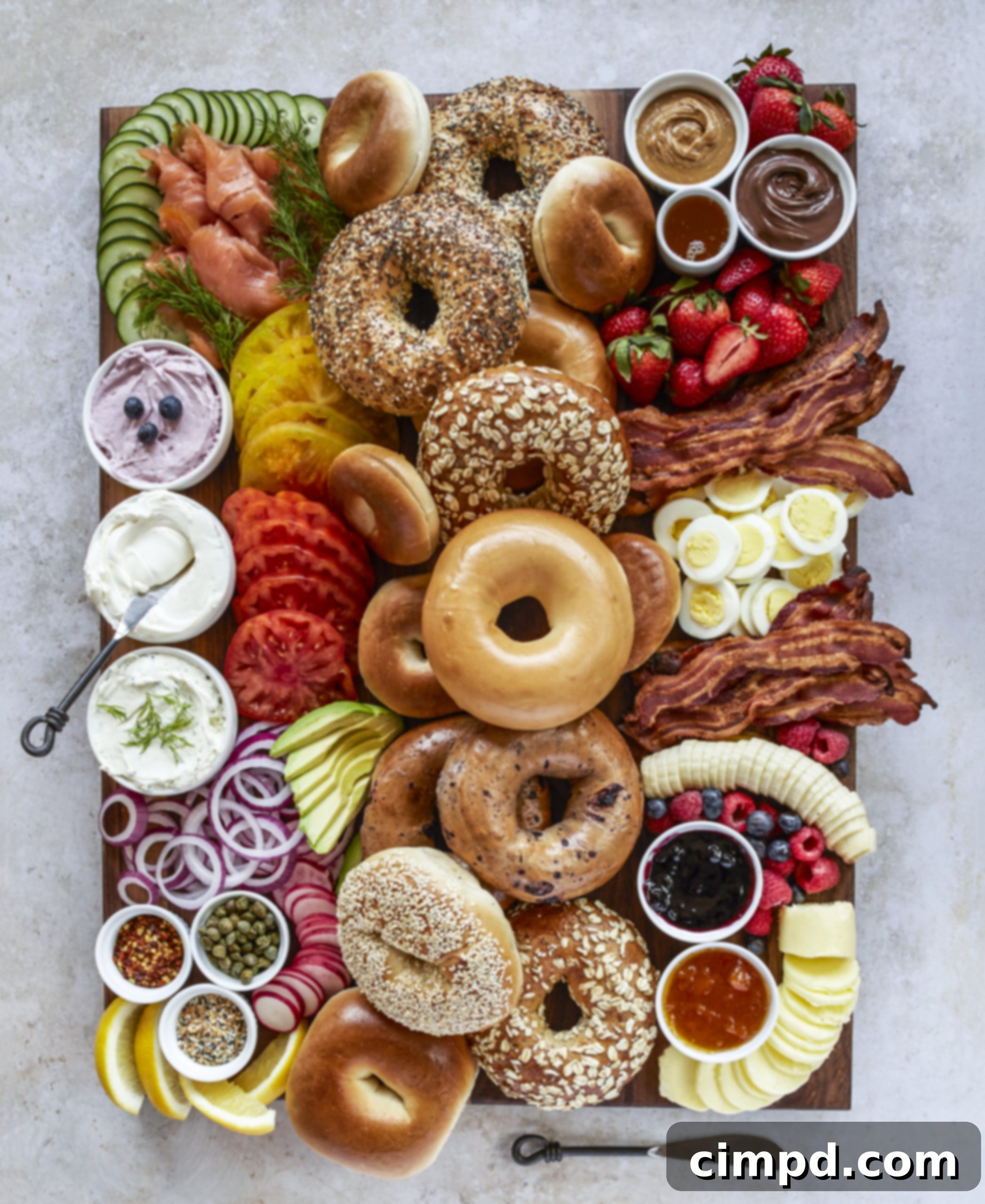 Delicious Bagel Board featuring assorted bagels, fresh fruit, savory bacon, and a selection of creamy spreads