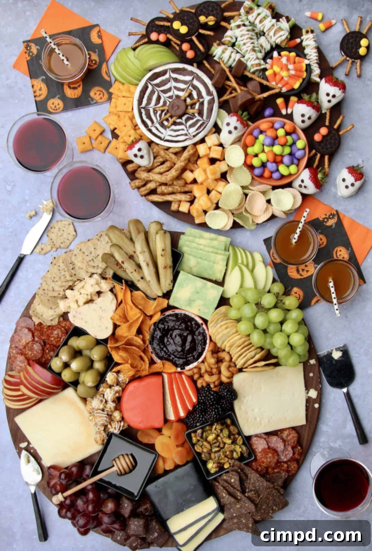 A close-up of a Halloween Cheese Board, showcasing a variety of cheeses, crackers, fruits, and small decorative bowls, by The BakerMama.