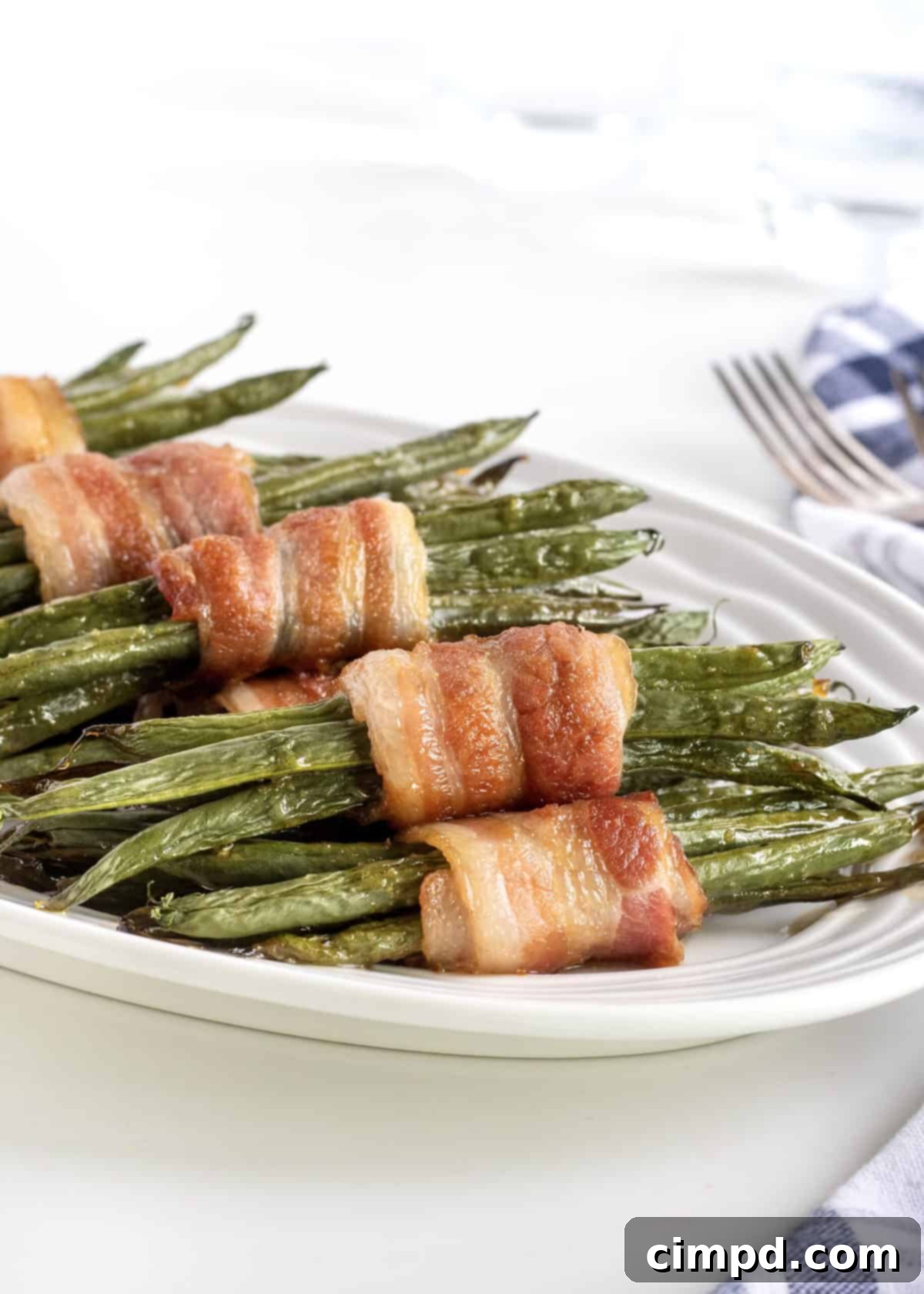 Crispy bacon-wrapped Green Bean Bundles with a sweet and savory glaze, ready to serve at a holiday feast.