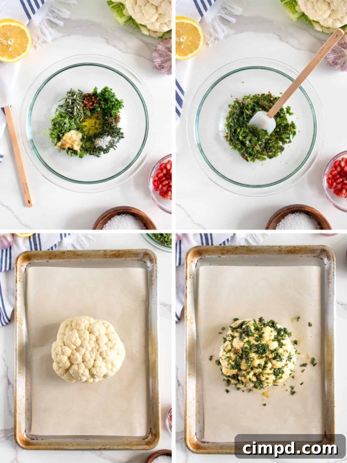 A whole cauliflower head being rubbed with a herb and garlic marinade on a baking sheet.