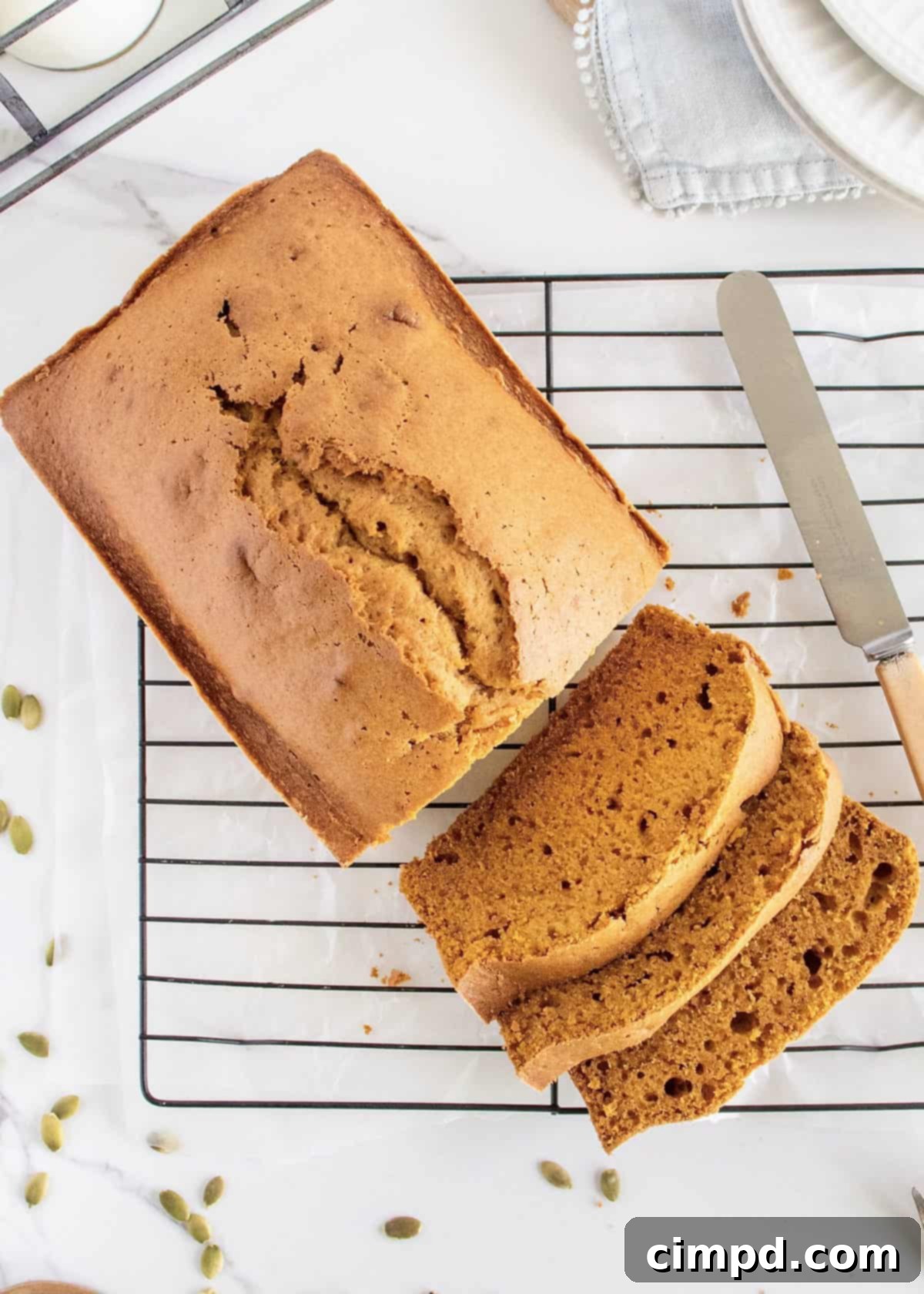 A slice of Perfect Pumpkin Bread served on a plate with butter