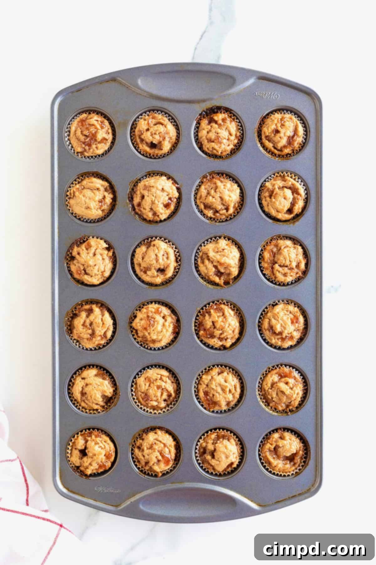 Peanut Butter and Jelly Muffin Bites 9 24 mini peanut butter and jelly muffins in an aluminum muffin pan.