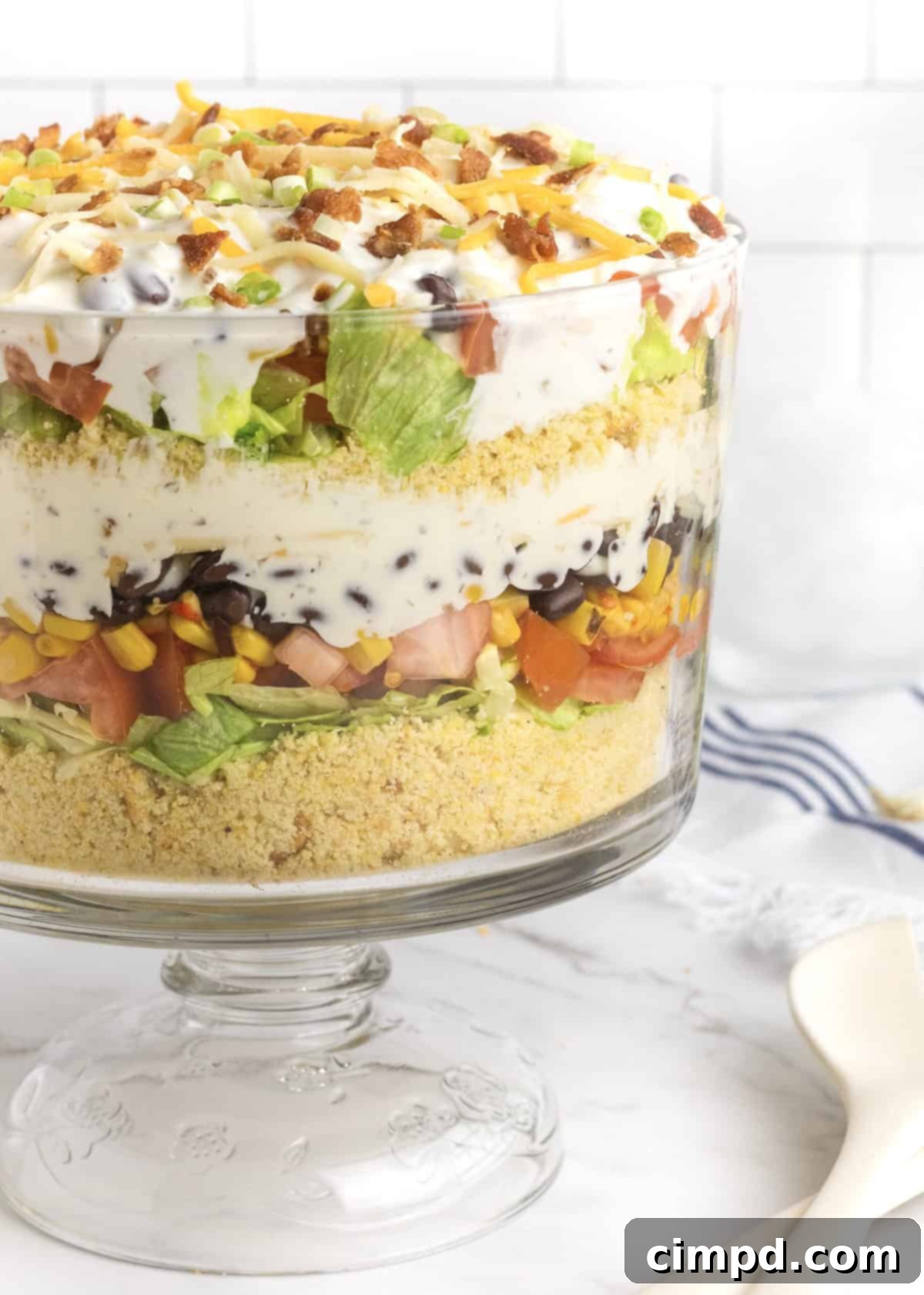 Southern Stacked Cornbread Medley 2 A beautifully presented layered cornbread salad in a clear glass bowl, showcasing vibrant ingredients.