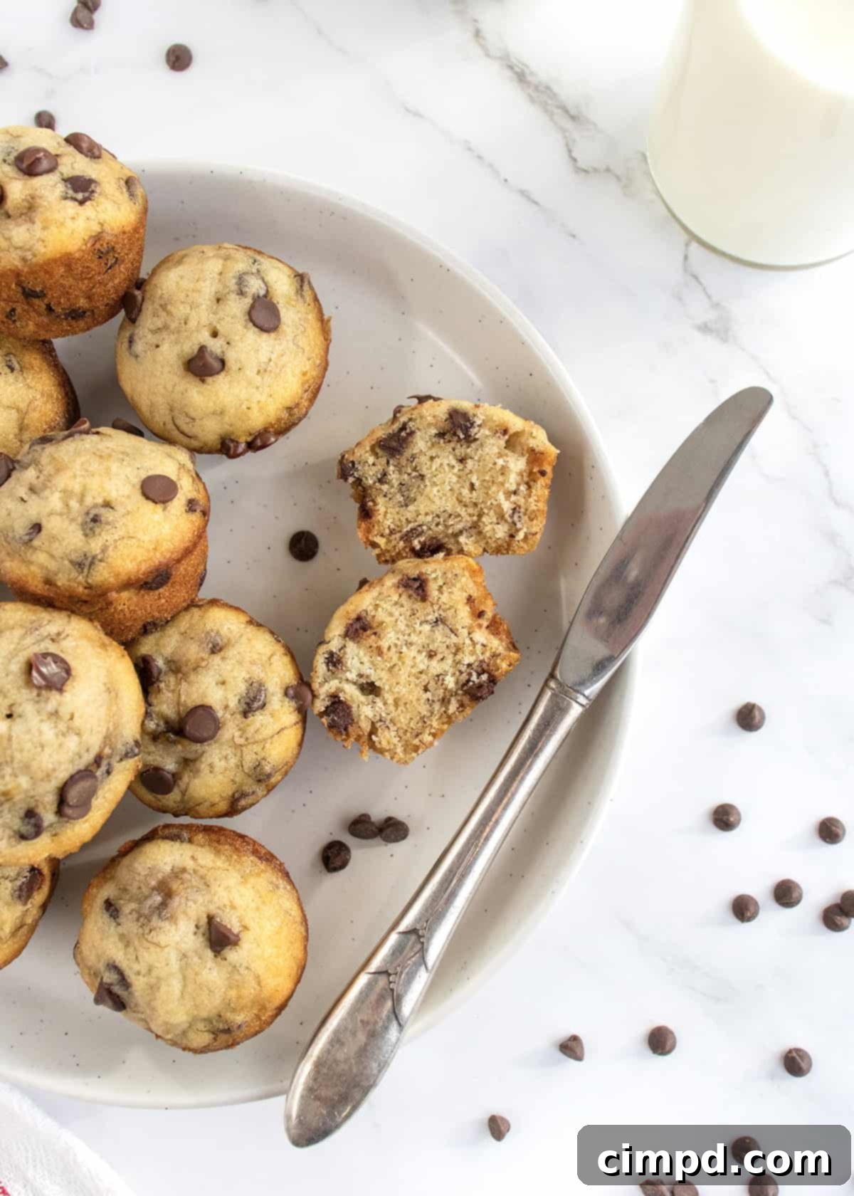 Ingredients laid out for Mini Banana Chocolate Chip Muffins recipe including mashed bananas, chocolate chips, flour, and butter.