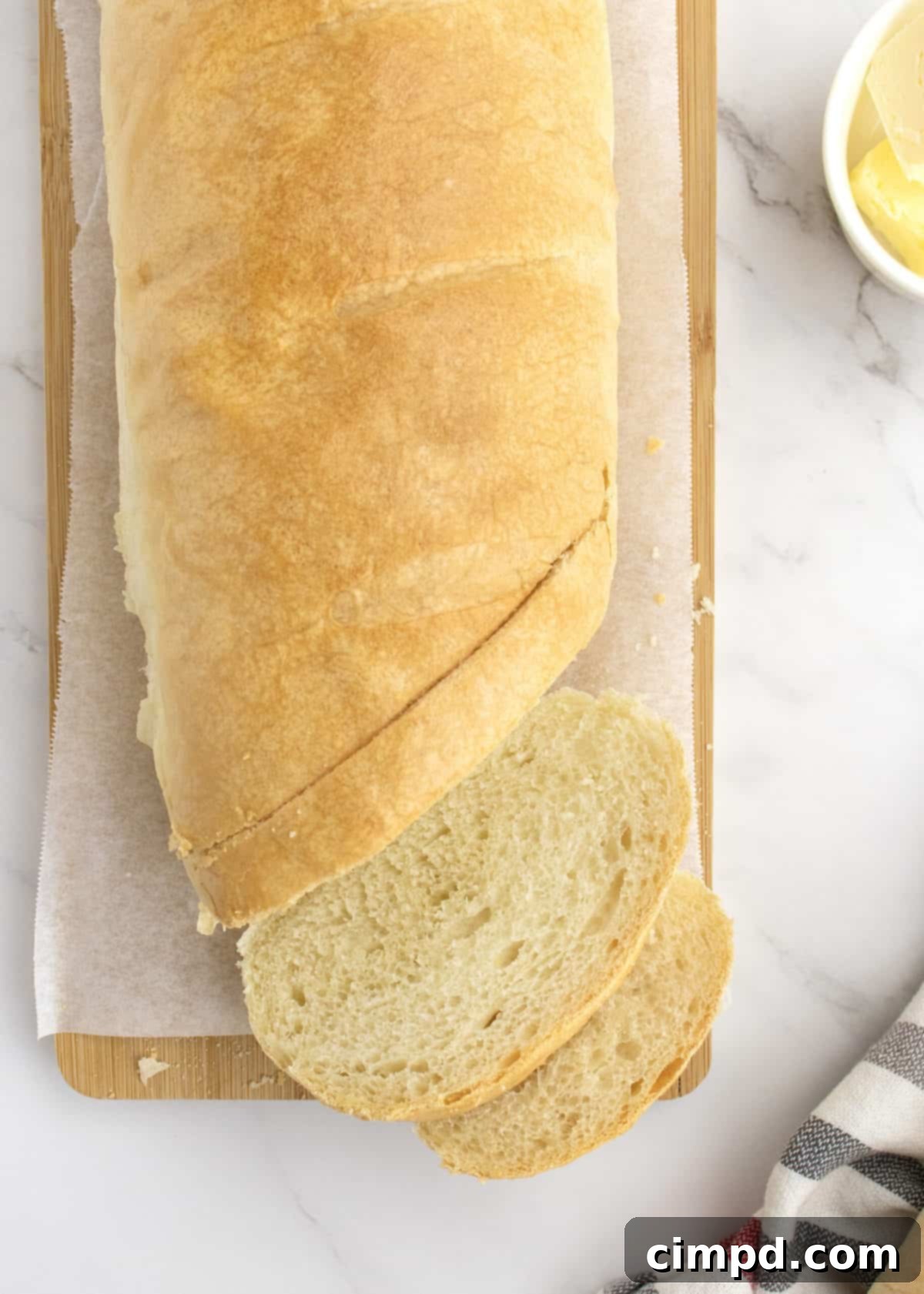 A freshly baked, golden brown loaf of 5-Ingredient Homemade French Bread, cooling on a wire rack, steam gently rising.