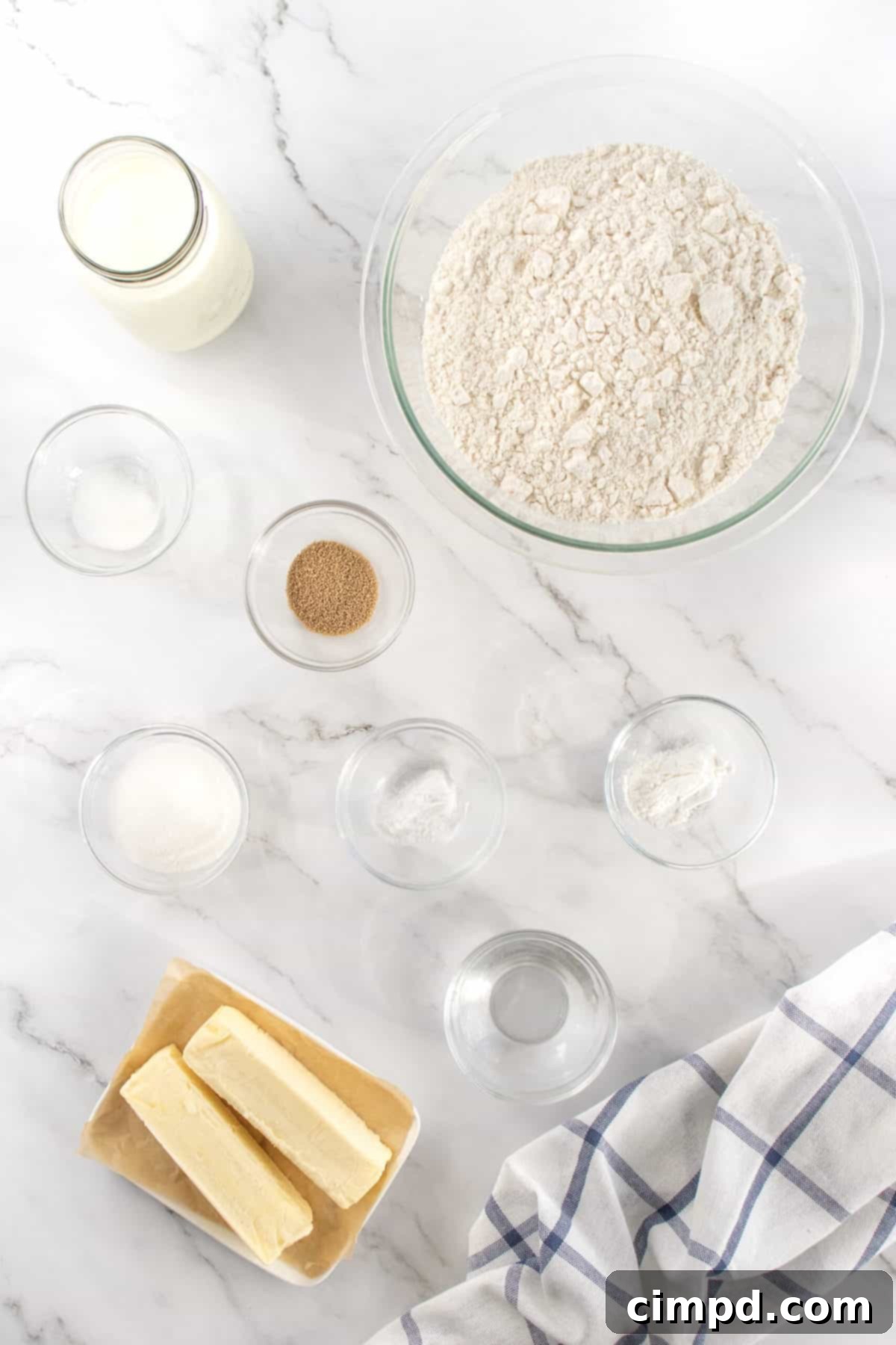 Heavenly Fluffy Biscuits 5 Various essential ingredients for baking Angel Biscuits displayed on a clean kitchen counter.