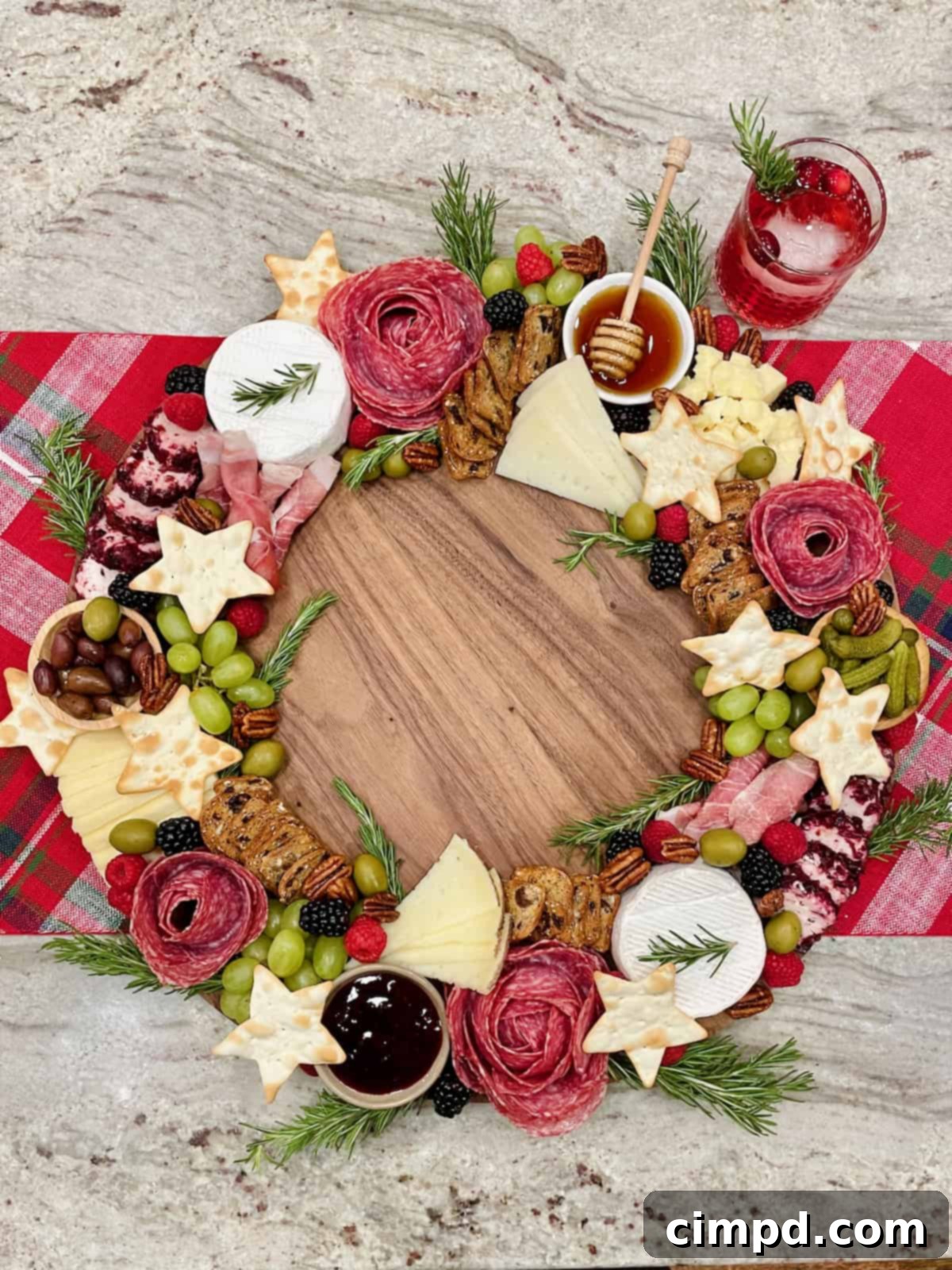A beautifully assembled Charcuterie Wreath Board resting on a festive red and white table runner, surrounded by holiday decor.