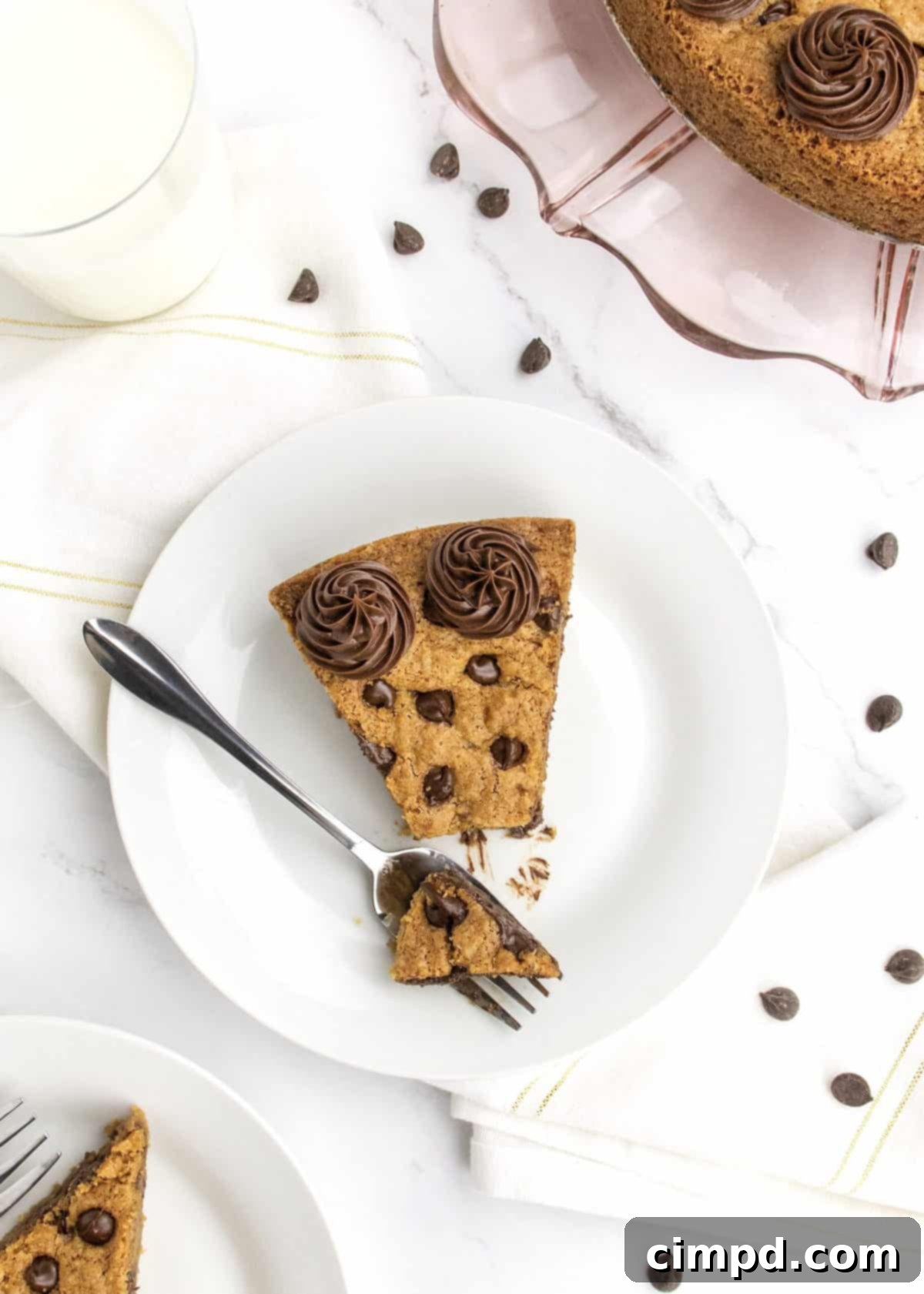 Assortment of chocolate chip cookies and a slice of cookie cake on a table