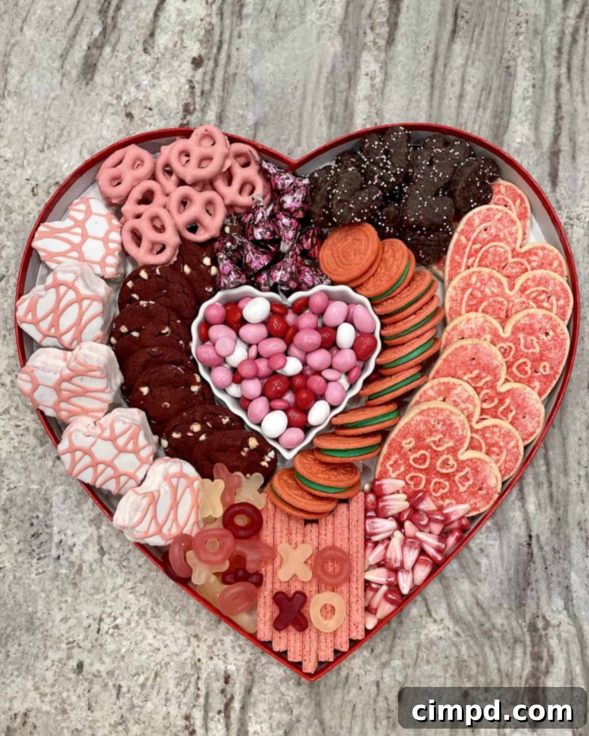 A festive Valentine's Day Dessert Board arranged on a heart-shaped candy box lid.
