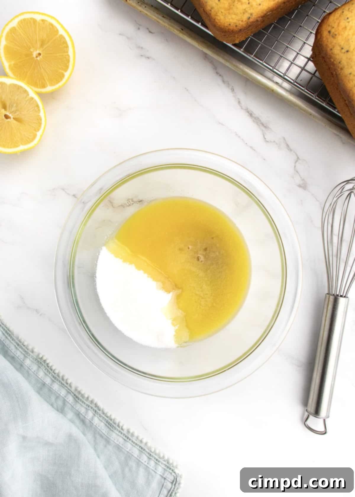 Preparing the citrus glaze in a bowl with a whisk, by The BakerMama