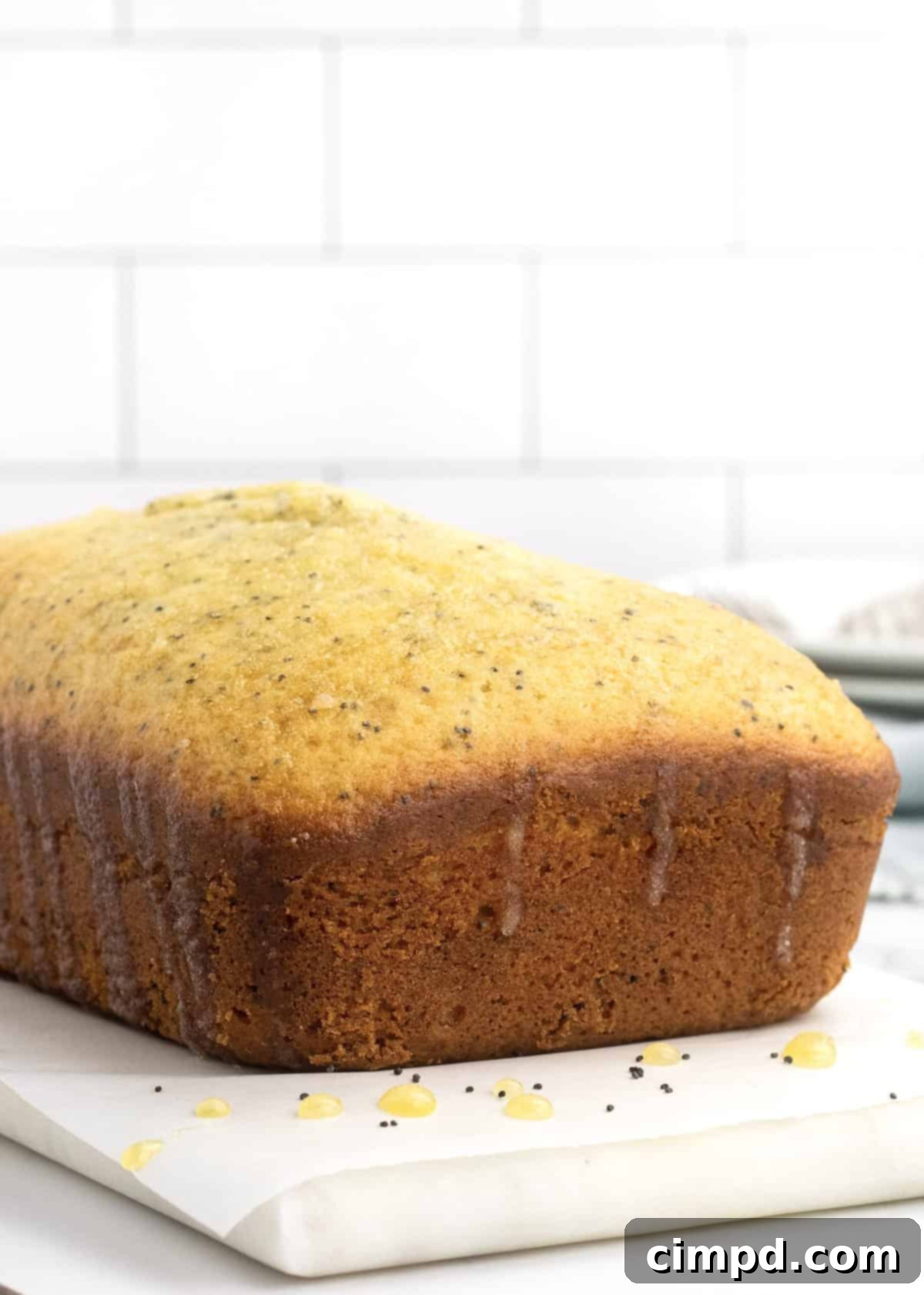 A beautifully sliced loaf of Lemon Poppy Seed Bread, ready to be enjoyed, by The BakerMama
