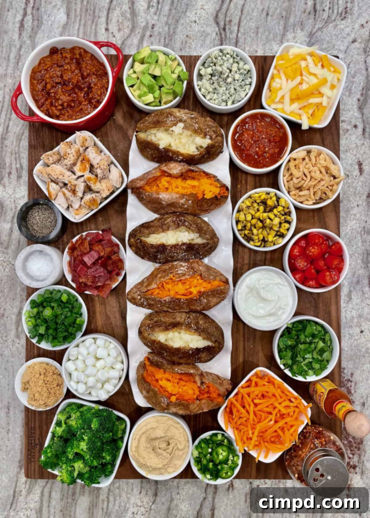 Build-Your-Own Baked Potato Board by The BakerMama, featuring baked potatoes with numerous toppings.