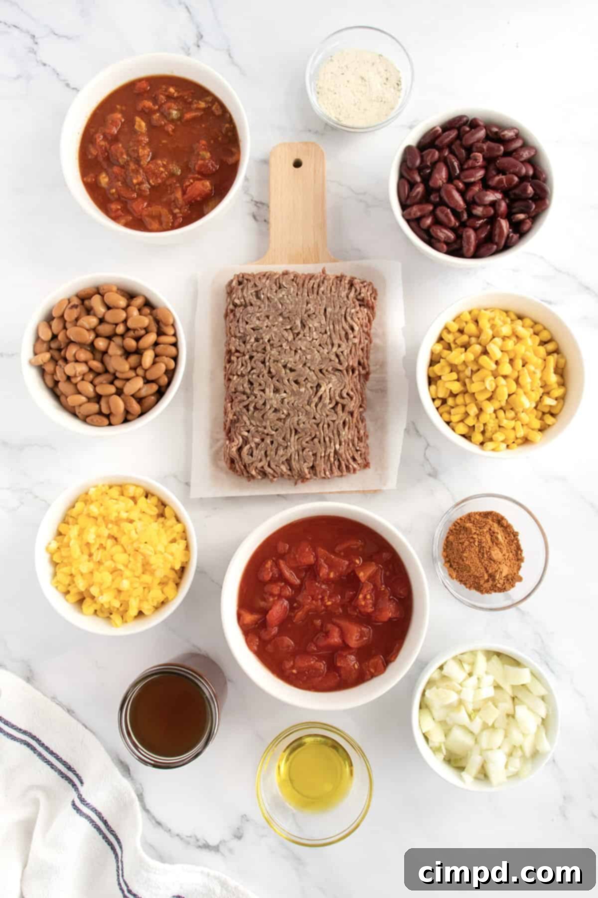 Assortment of fresh ingredients for taco soup, including ground beef, corn, beans, and seasonings.