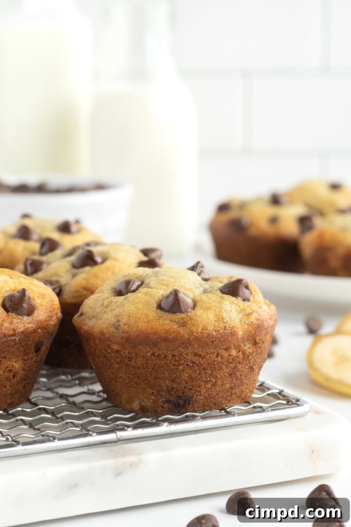 Six banana chocolate chip muffins on a wire rack.