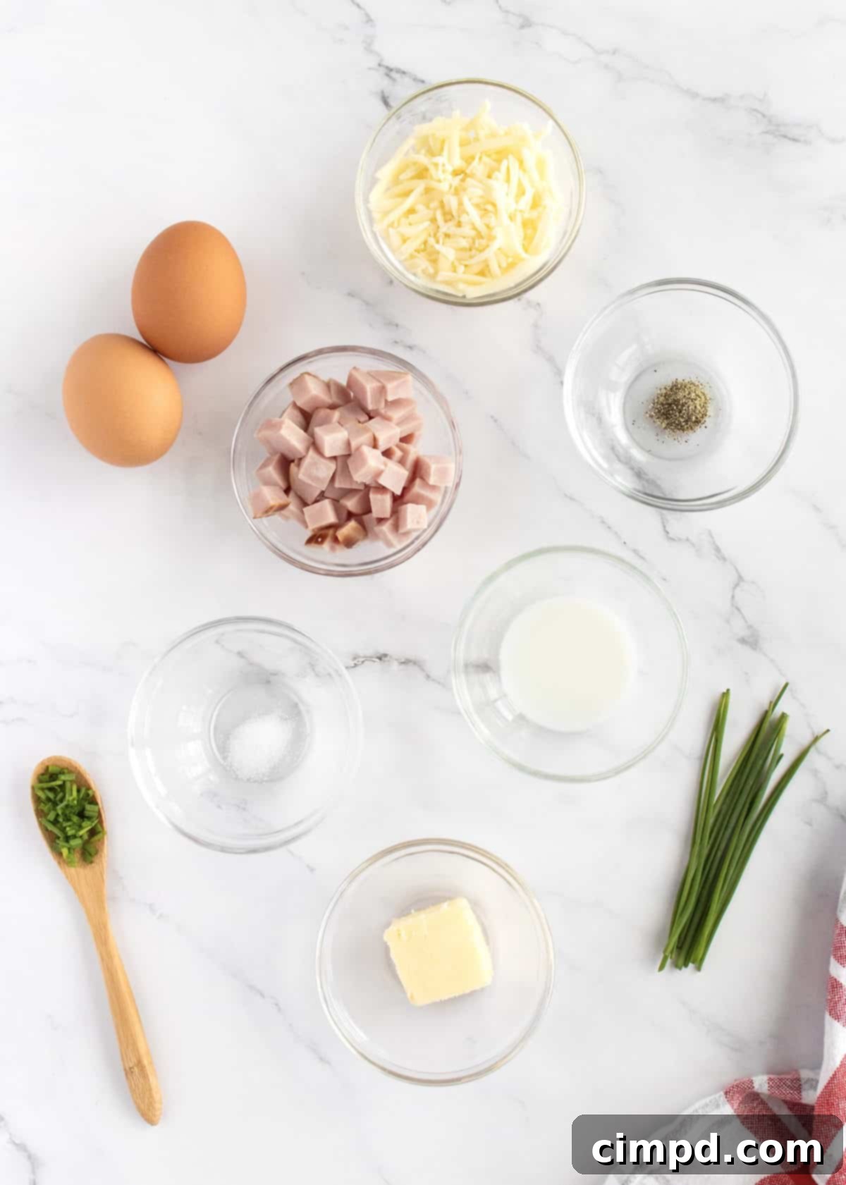 The Ultimate Omelet Guide 4 Ingredients for making an omelet laid out on a kitchen counter.