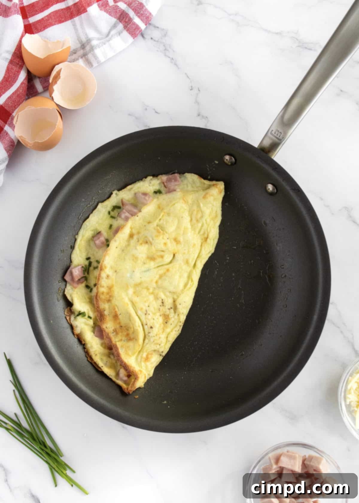 The Ultimate Omelet Guide 7 A freshly cooked and folded omelet being slid onto a plate for serving.