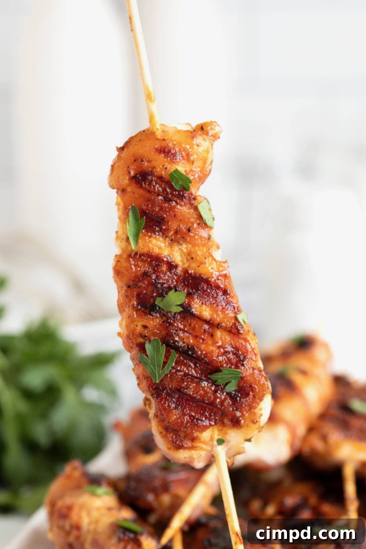Crispy Bacon Chicken Skewers 4 A single bacon wrapped chicken tender on a bamboo skewer, showcasing the golden-brown crispiness.