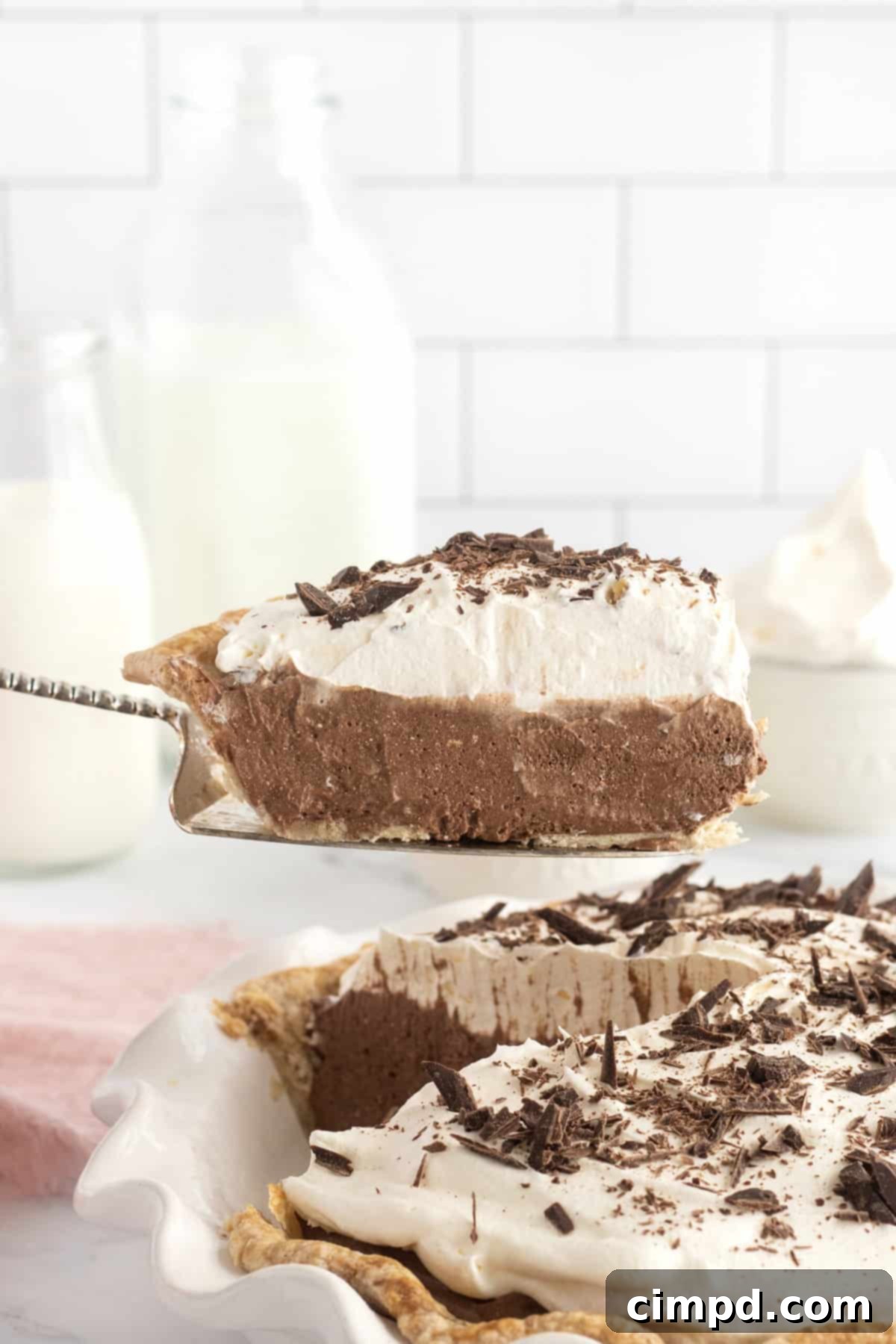 A close-up of a slice of Chocolate Cream Pie, showcasing its rich, dark filling and fluffy whipped topping.