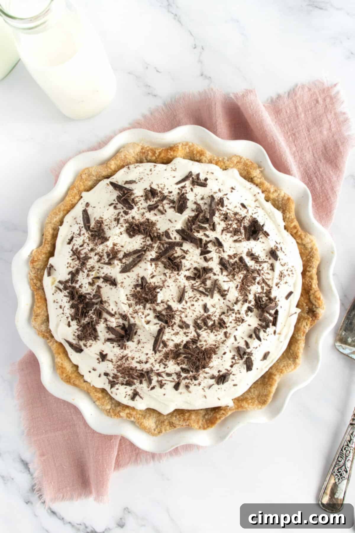 A beautifully garnished Chocolate Cream Pie, topped with whipped cream and chocolate shavings, ready to serve.